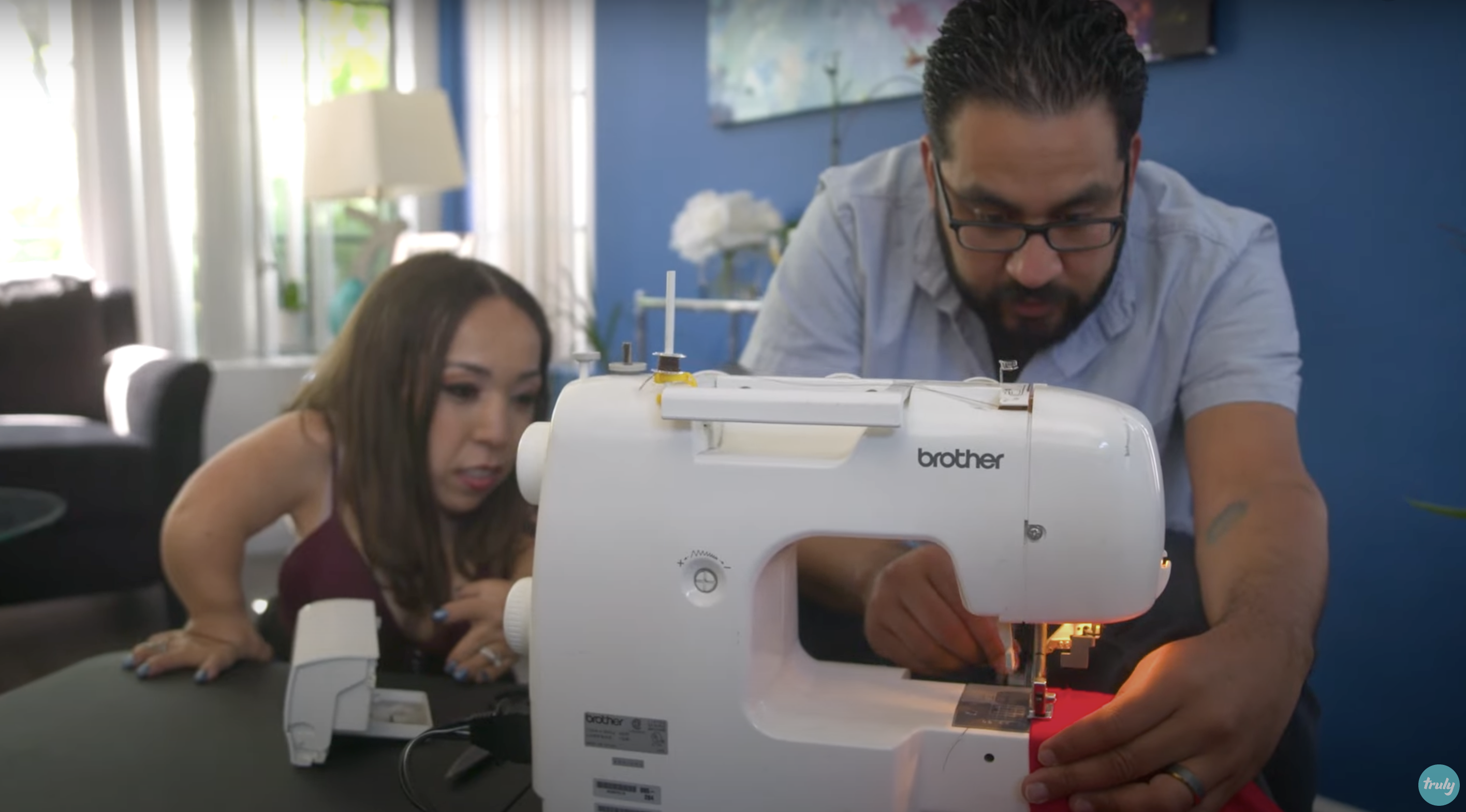 Bryan uses a sewing machine to make alterations to Yesi's shirt | Source: Youtube.com/Truly
