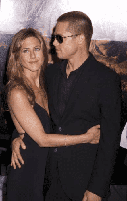 Brad Pitt and Jennifer Aniston embrace each other at the premiere for "Troy," at the Ziegfeld Theater, on October 4 2004 | Source:  Brian ZAK/Gamma-Rapho via Getty Images