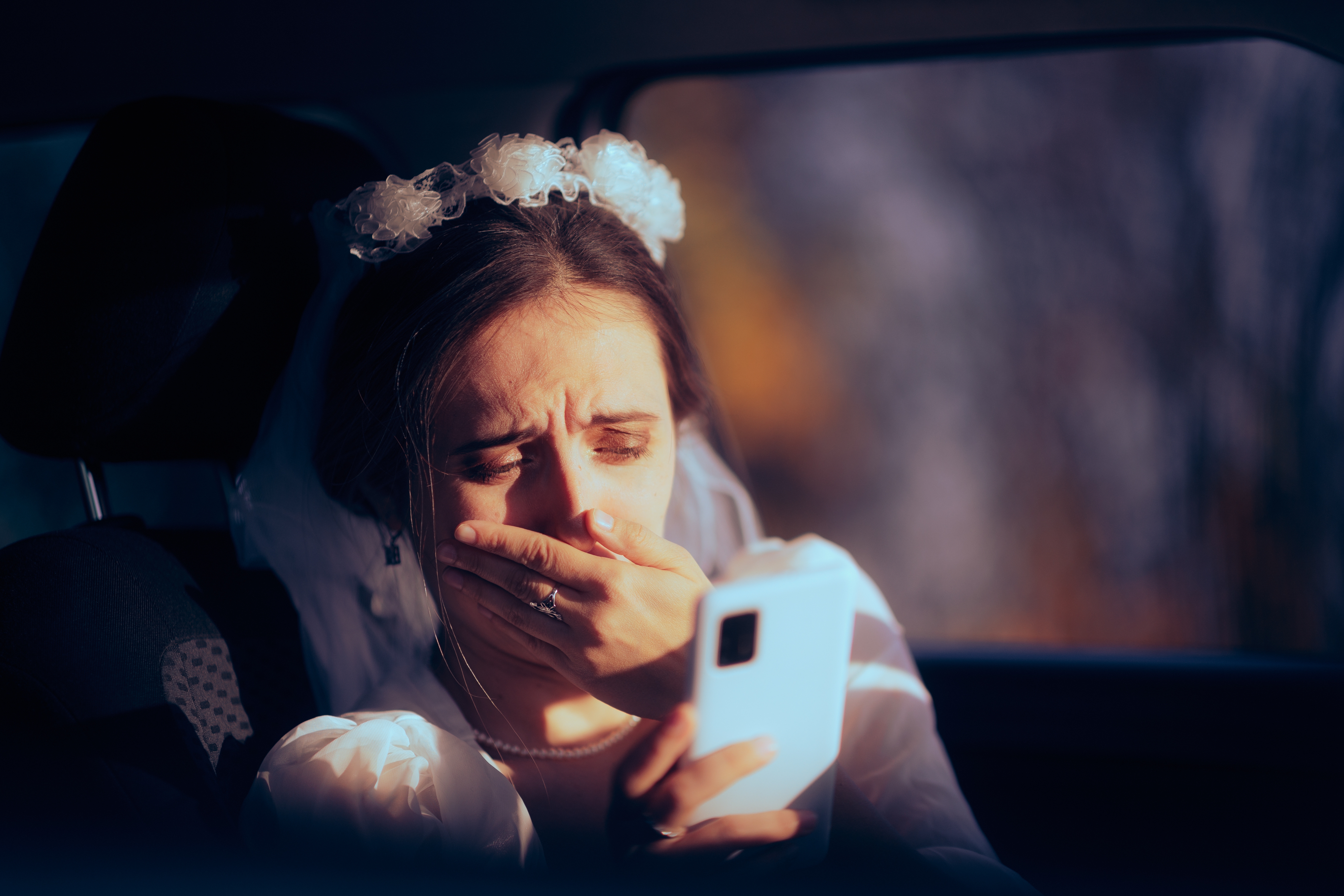An image of a bride reading something upsetting on her phone | Source: Shutterstock