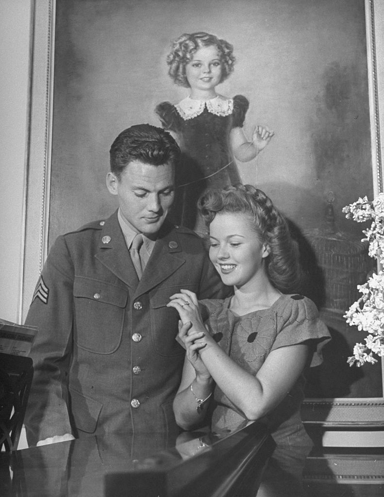 Shirley Temple and Sgt. John Agar, looking at the ring on her finger. | Source: Getty Images