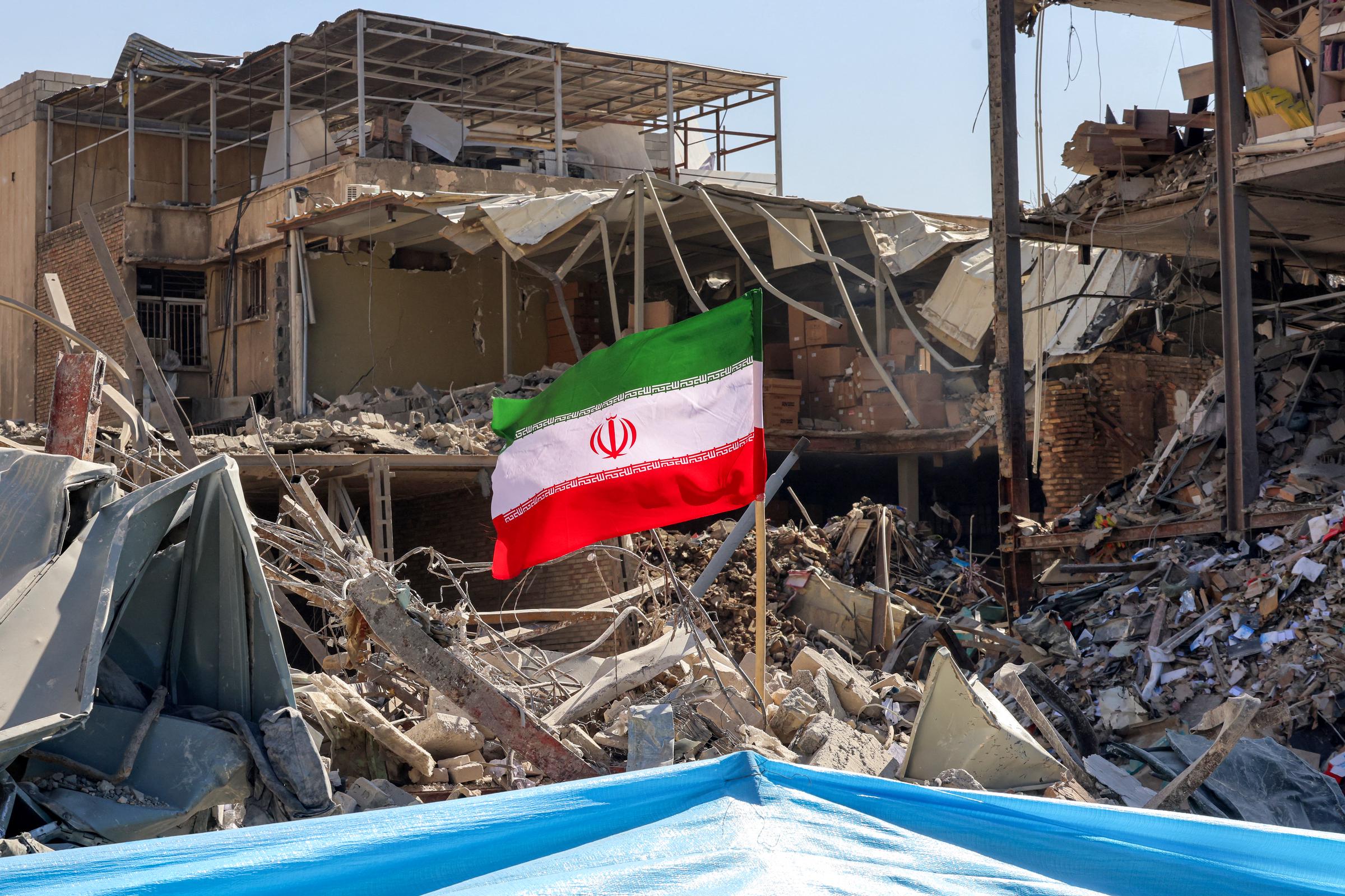 An Iranian flag is placed amids rubble and debris next to a destroyed residential building near Ferdowsi square in Tehran on March 3, 2026 | Source: Getty Images