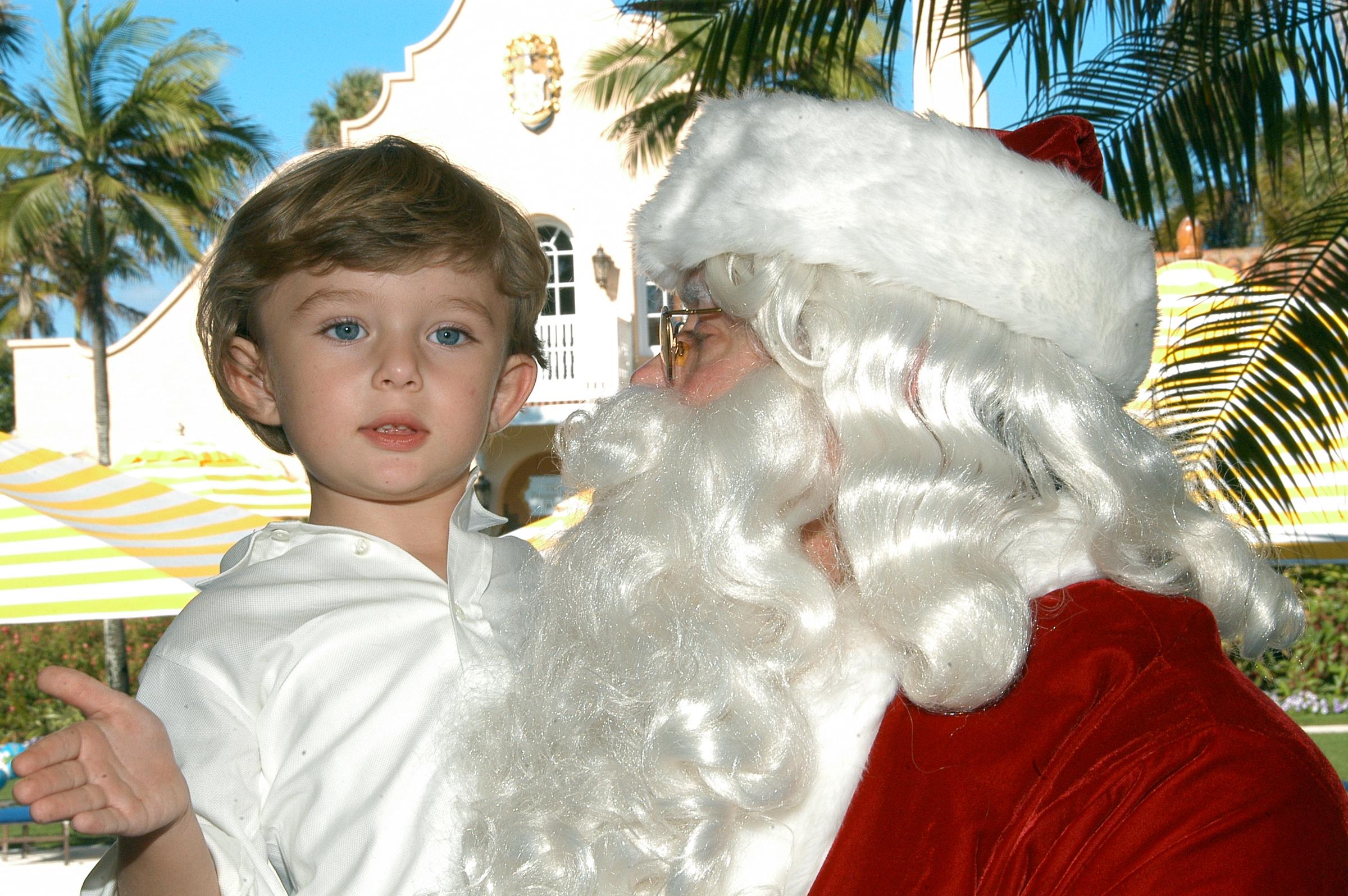 Barron Trump is carried by Santa Claus on Christmas Day at the Mar-a-Lago estate in Palm Beach, Florida, December 25, 2008. | Source: Getty Images