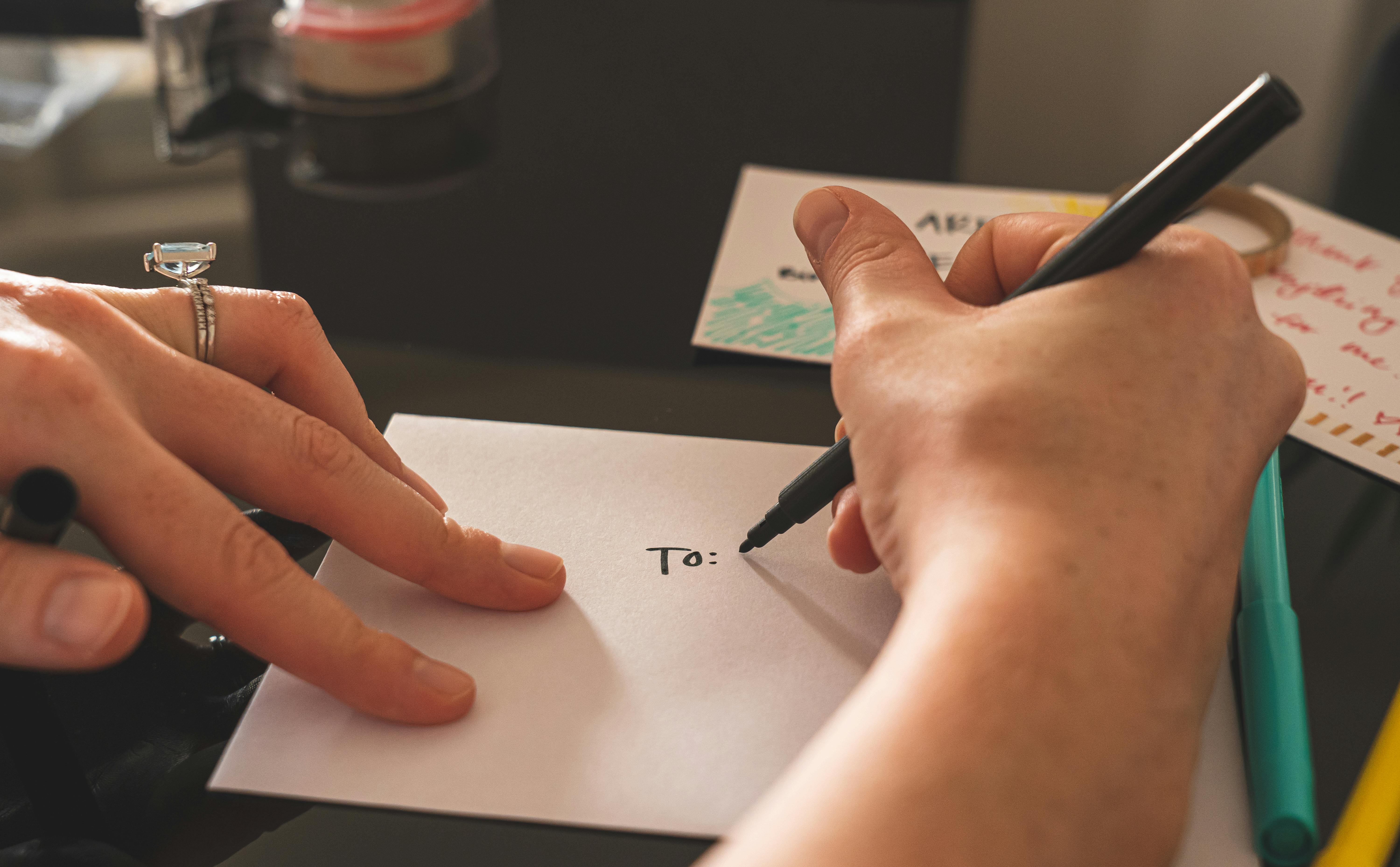 A person writing on an envelope | Source: Pexels