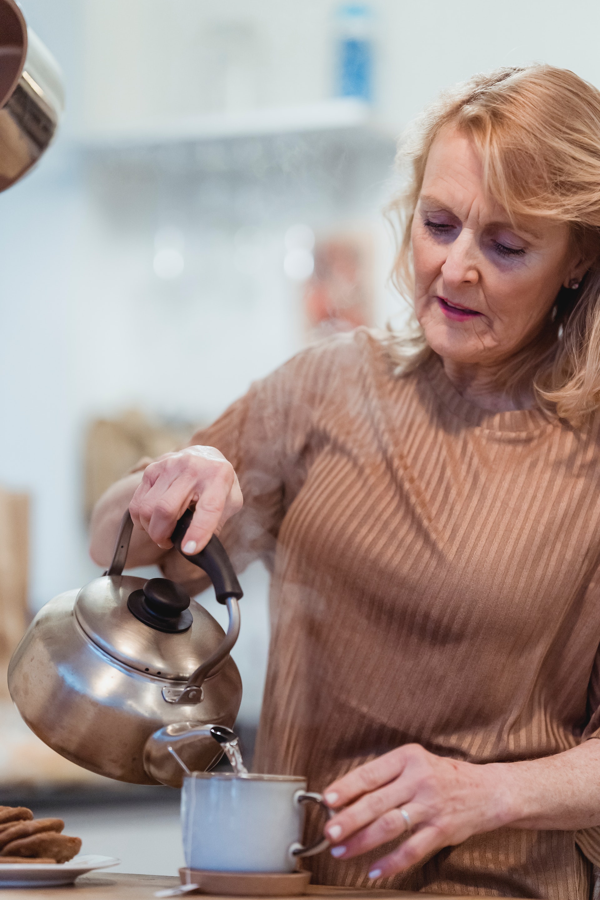 An older woman pouring water in a cup | Source: Pexels