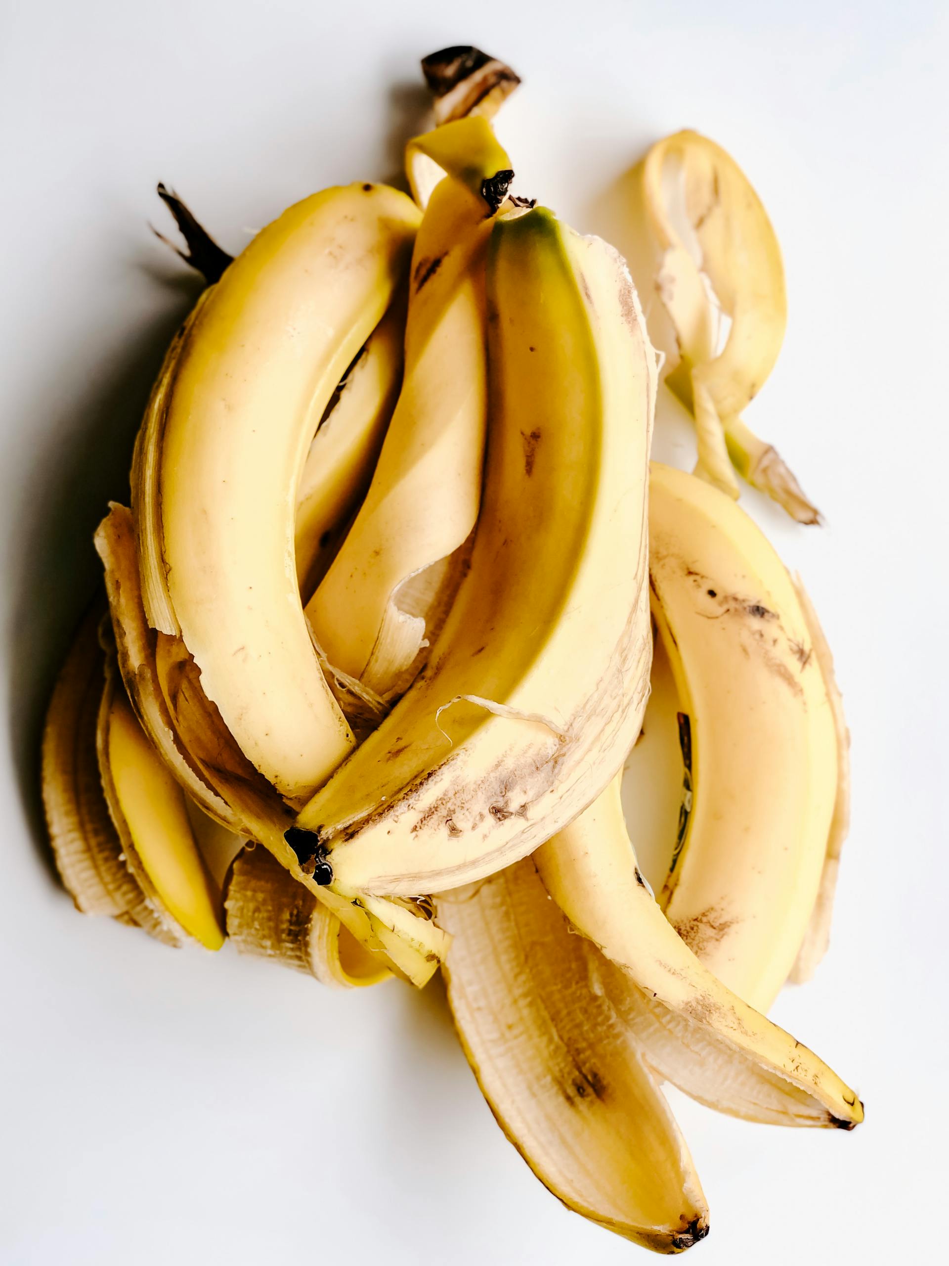 Yellow banana peels on a white surface | Source: Pexels