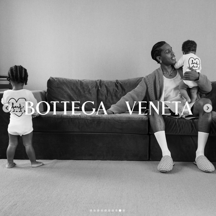 RZA stands with his back turned while A$AP Rocky sits on a couch holding Riot in a Bottega Veneta Father's Day campaign ad, posted in June 2024. | Source: Instagram/asaprocky