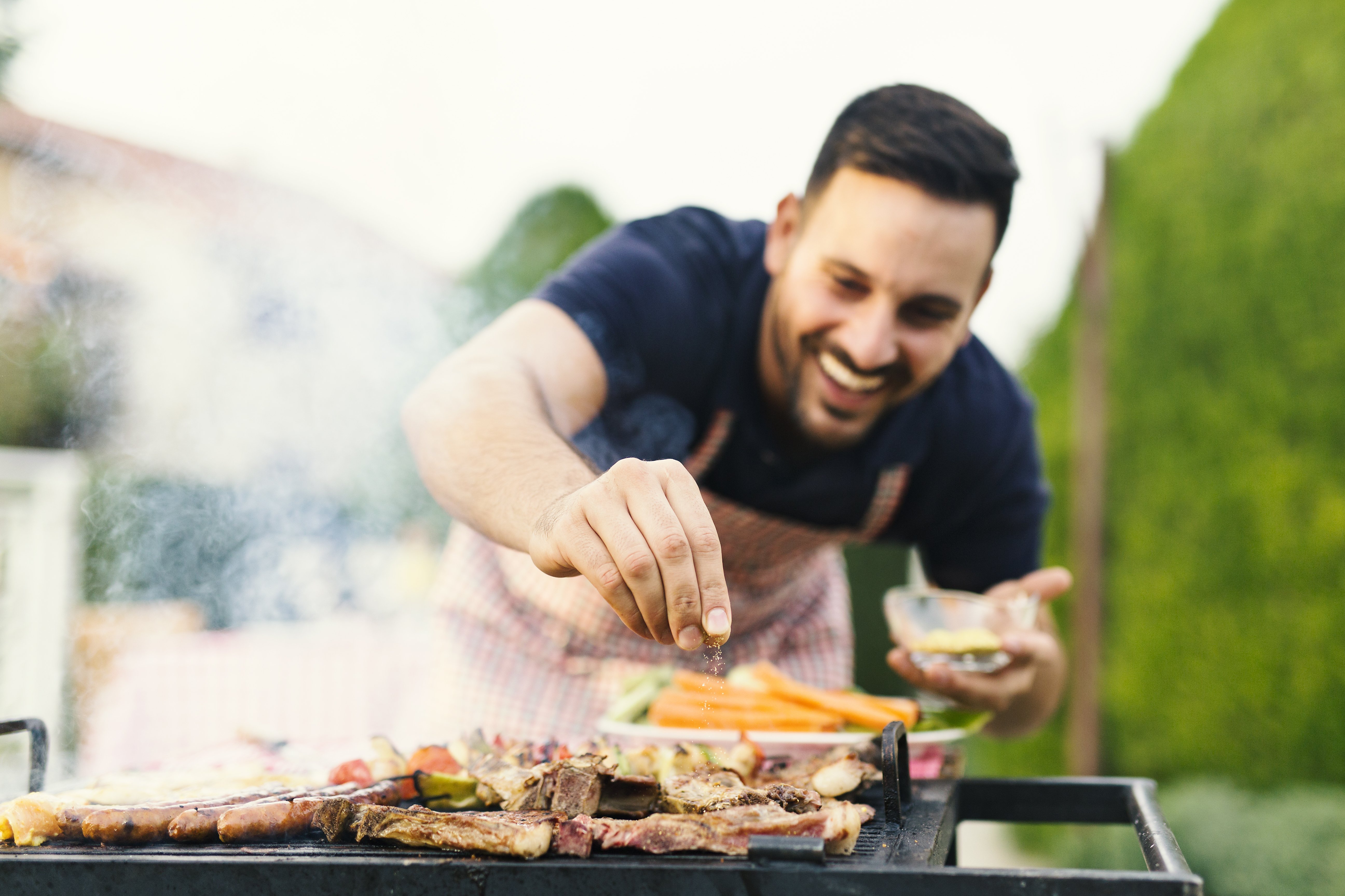 Un homme assaisonnant de la viande | Photo : Shutterstock Un homme assaisonnant de la viande | Photo : Shutterstock