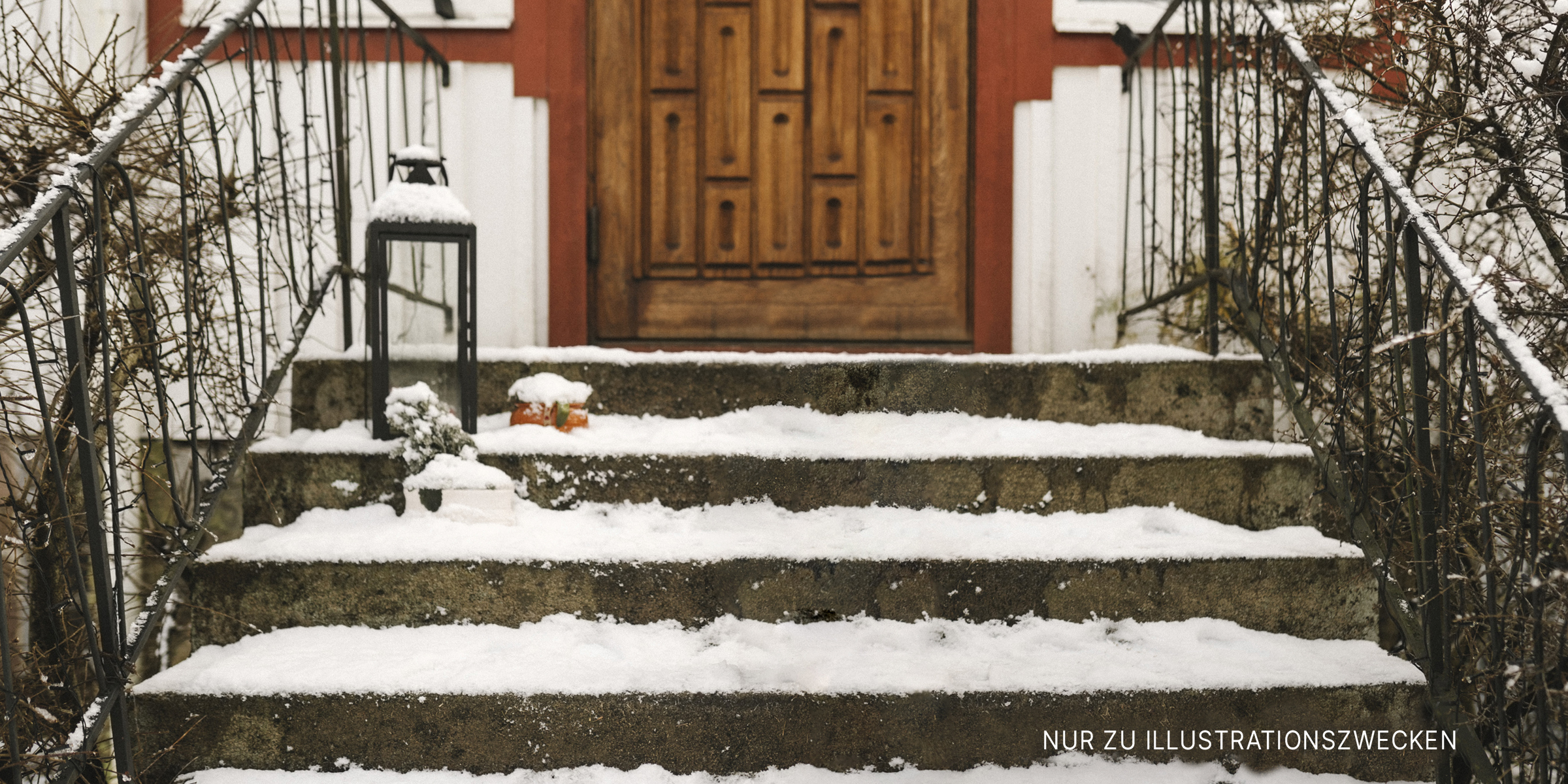 Eine schneebedeckte Treppe, die zu einer Türöffnung führt | Quelle: Getty Images