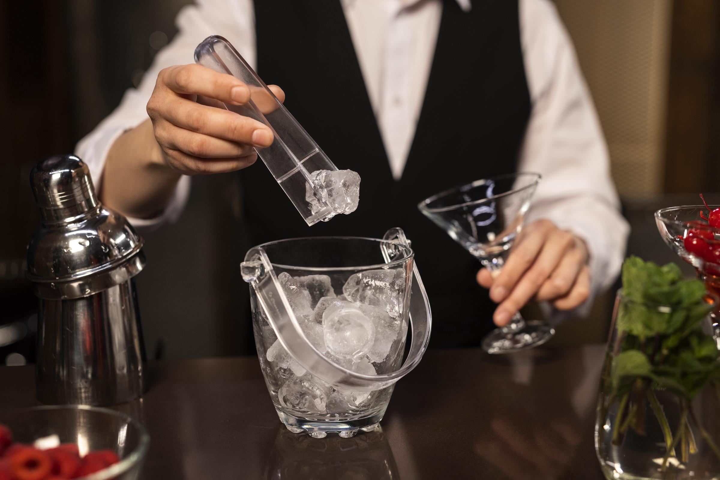 A restaurant worker preparing a drink on the rocks | Source: Freepik