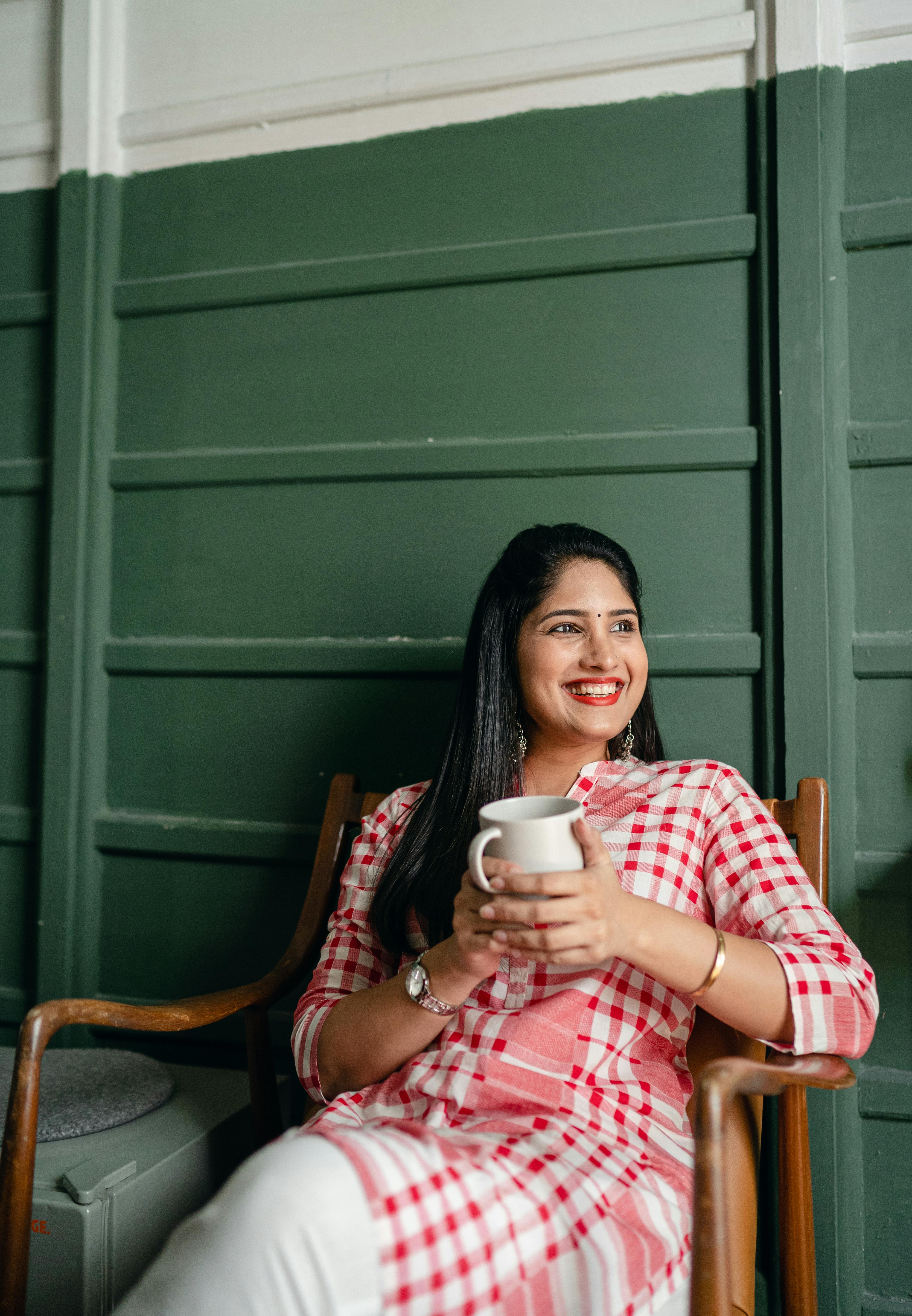 A happy woman drinking a beverage | Source: Pexels