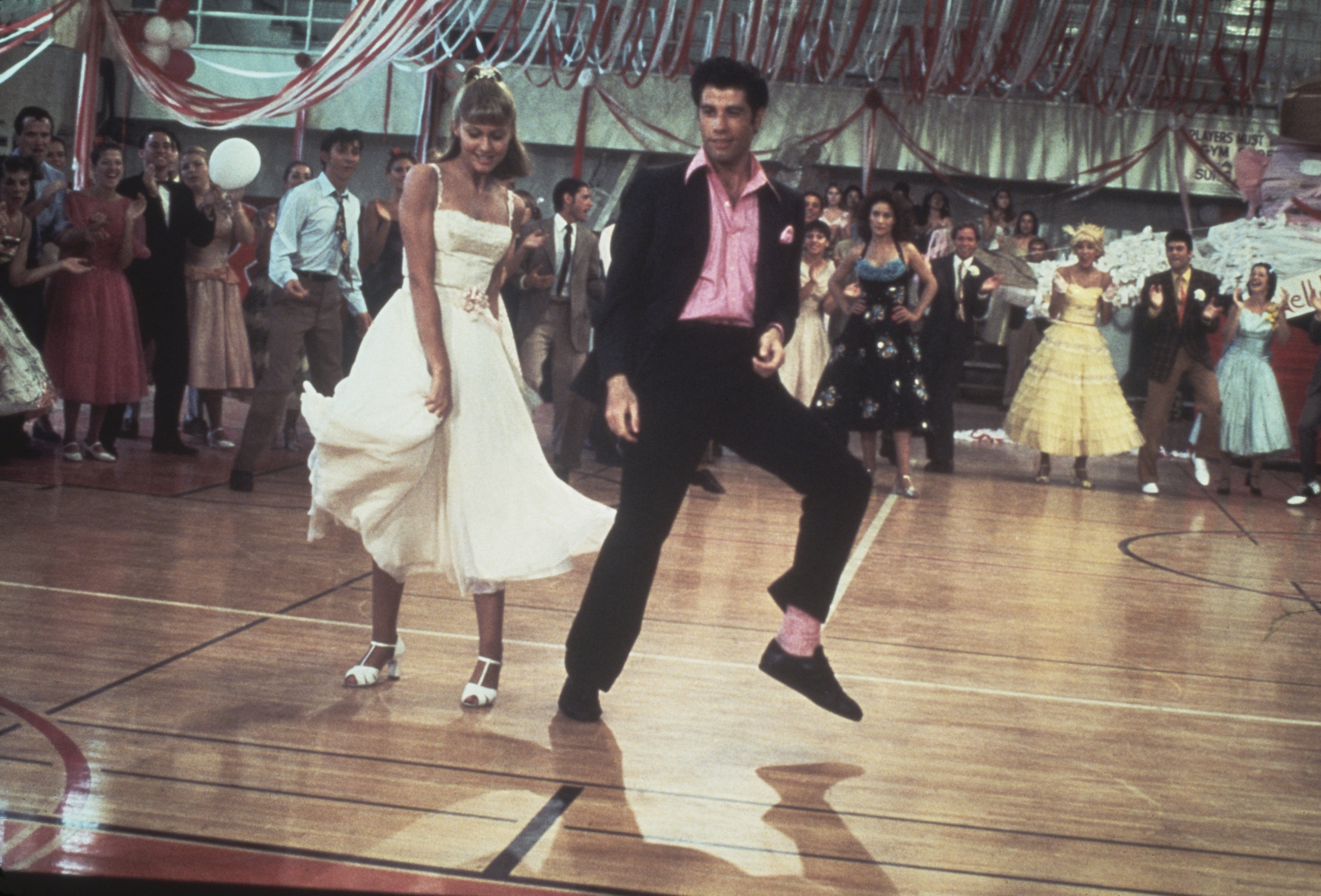 Olivia Newton-John and John Travolta dancing in a crowded high school gym in the movie, "Grease," in 1978. / Source: Getty Images