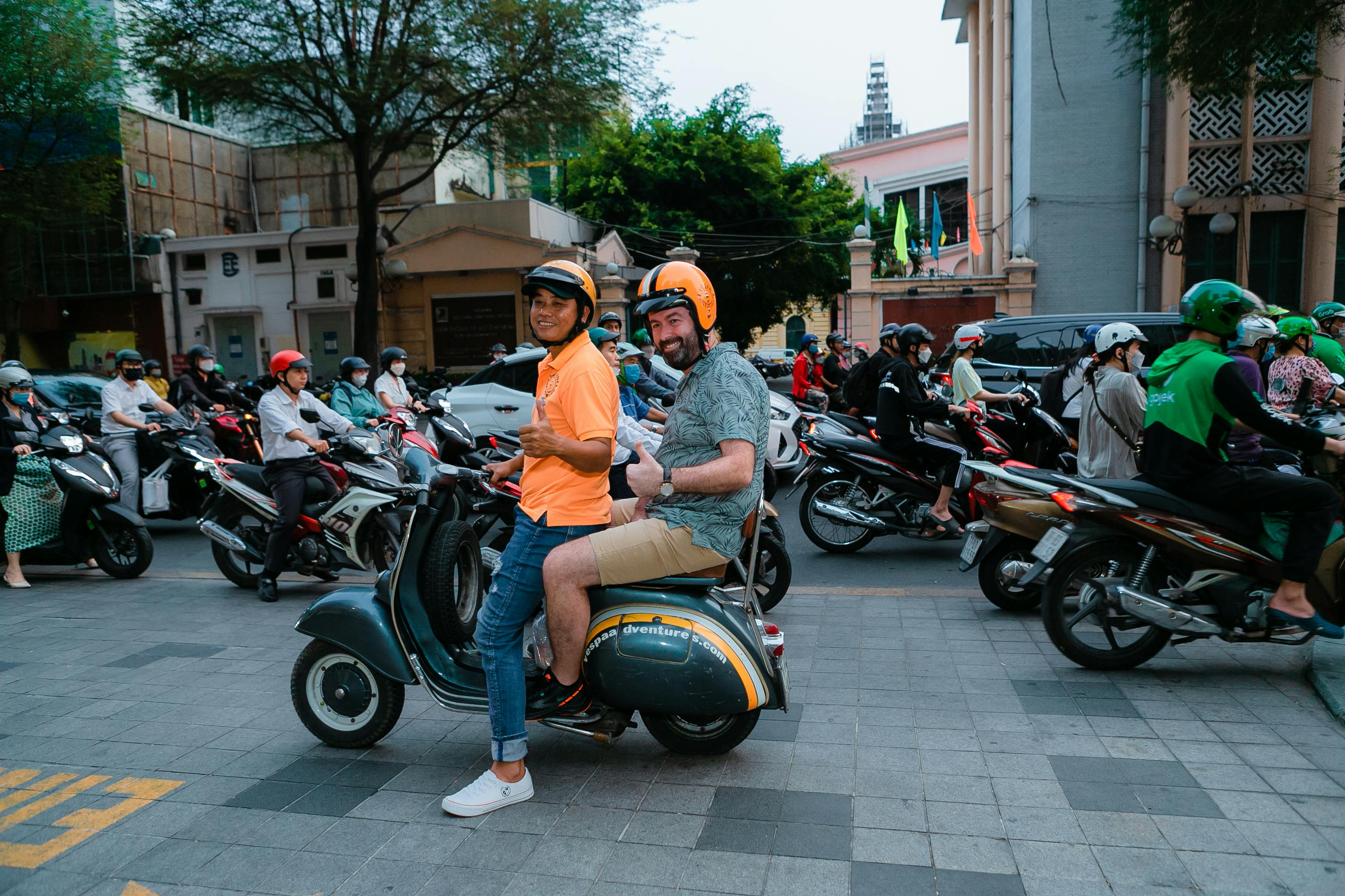 A tourist rides pillion on a motorbike through heavy traffic in Vietnam, reflecting the popularity of guided scooter tours | Source: Pexels