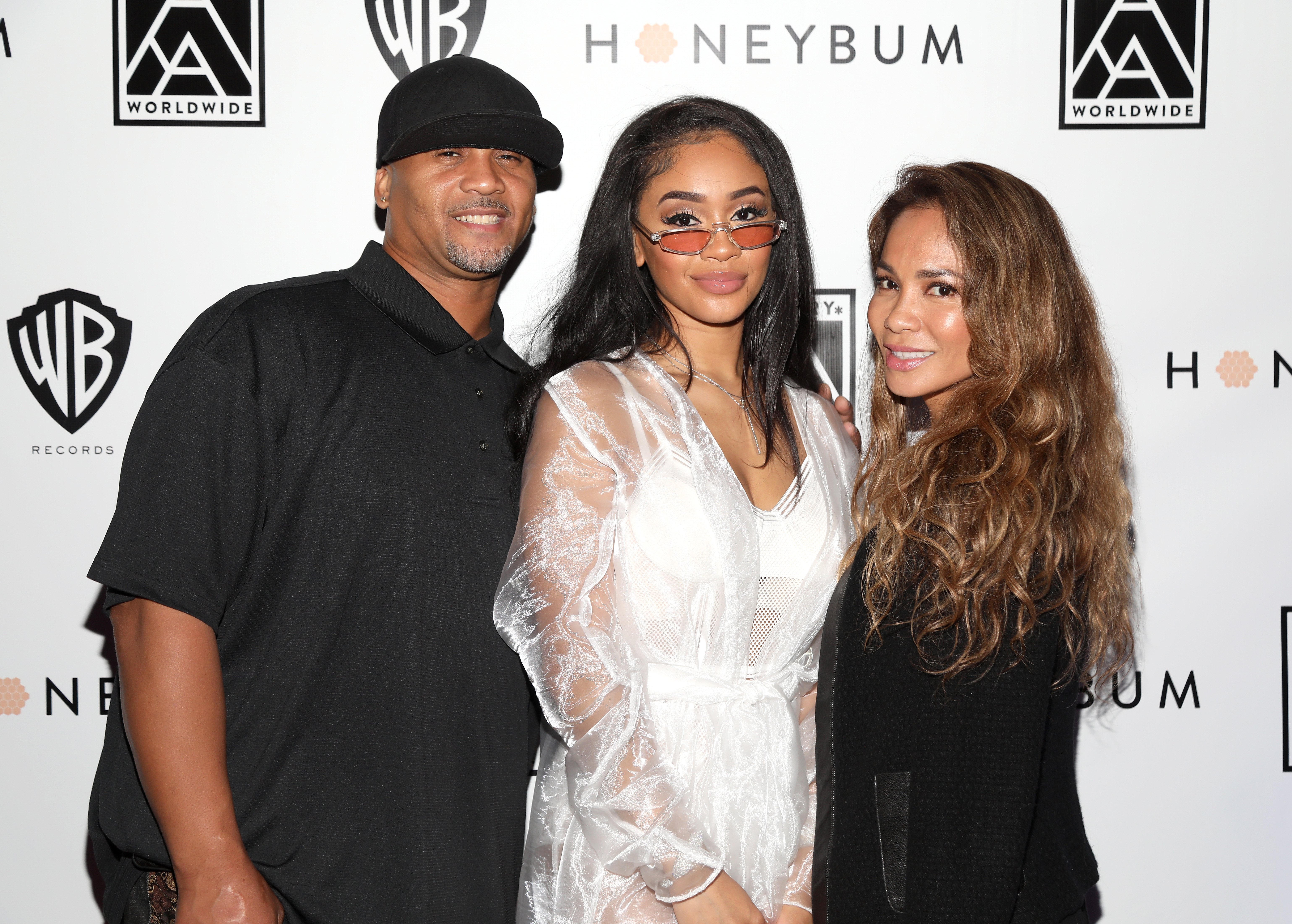 Saweetie poses with her parents, Johnny Harper and Trinidad Valentin, at her "High Maintenance" Listening Event on March 12, 2018, in Hollywood | Source: Getty Images