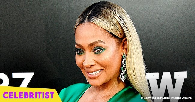 La La Anthony flaunts long legs and deep cleavage in skintight orange dress