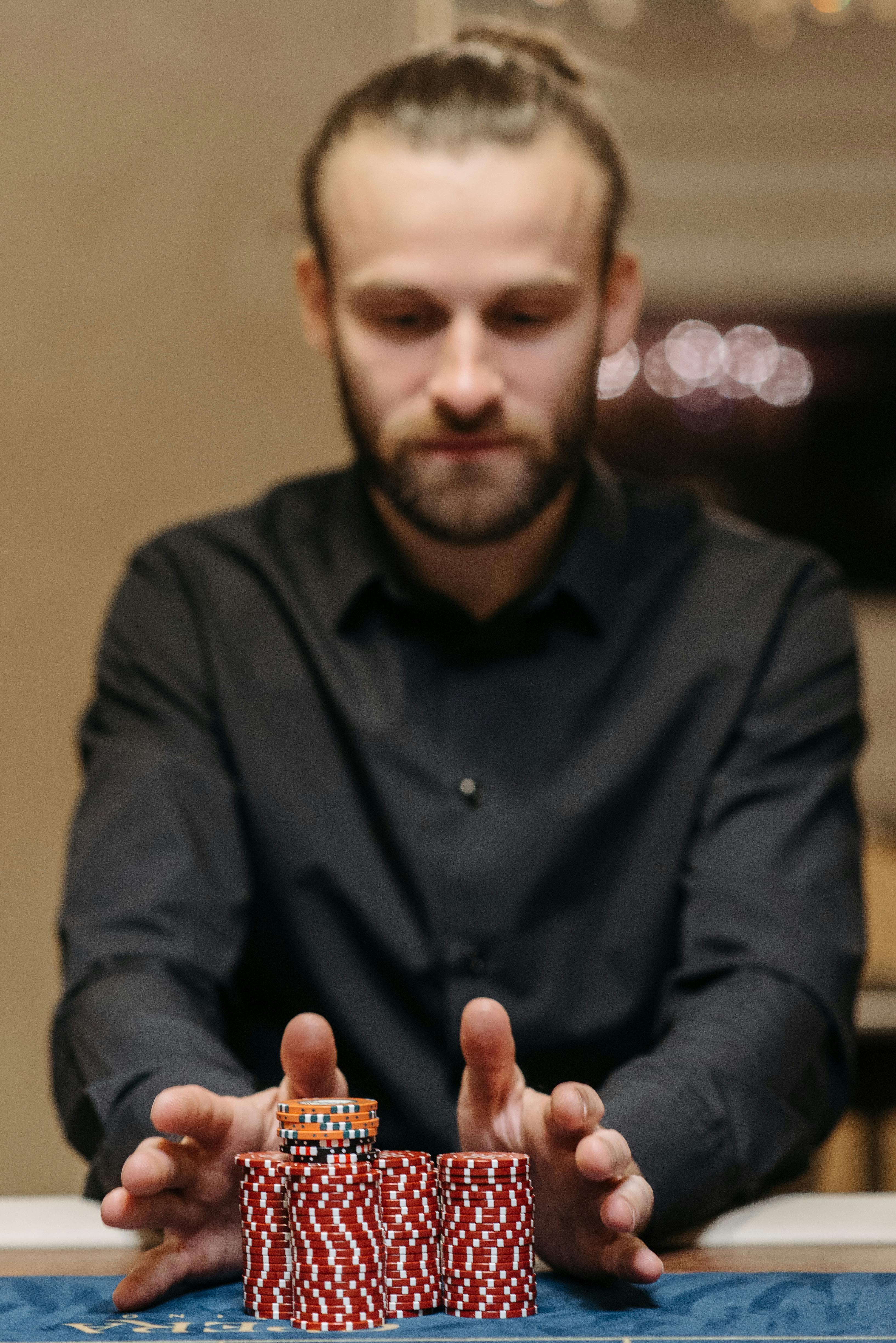 A man taking care of the poker chips on the table | Source: Pexels