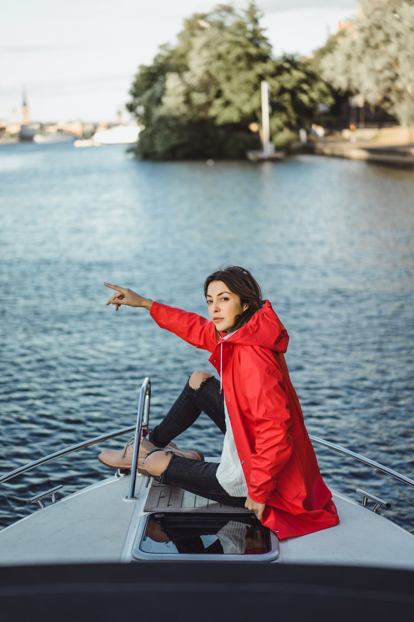 A woman pictured with her hand stretched overboard a boat | Source: Freepik