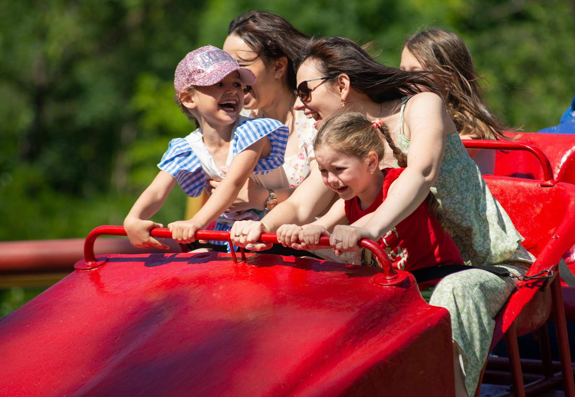 Women and children riding a rollercoaster in an amusement park | Source: Pexels