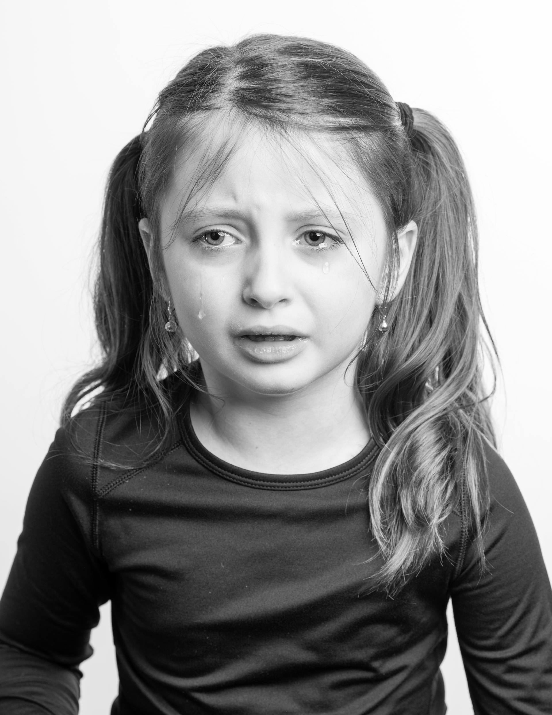 Grayscale of a teary-eyed little girl | Source: Pexels