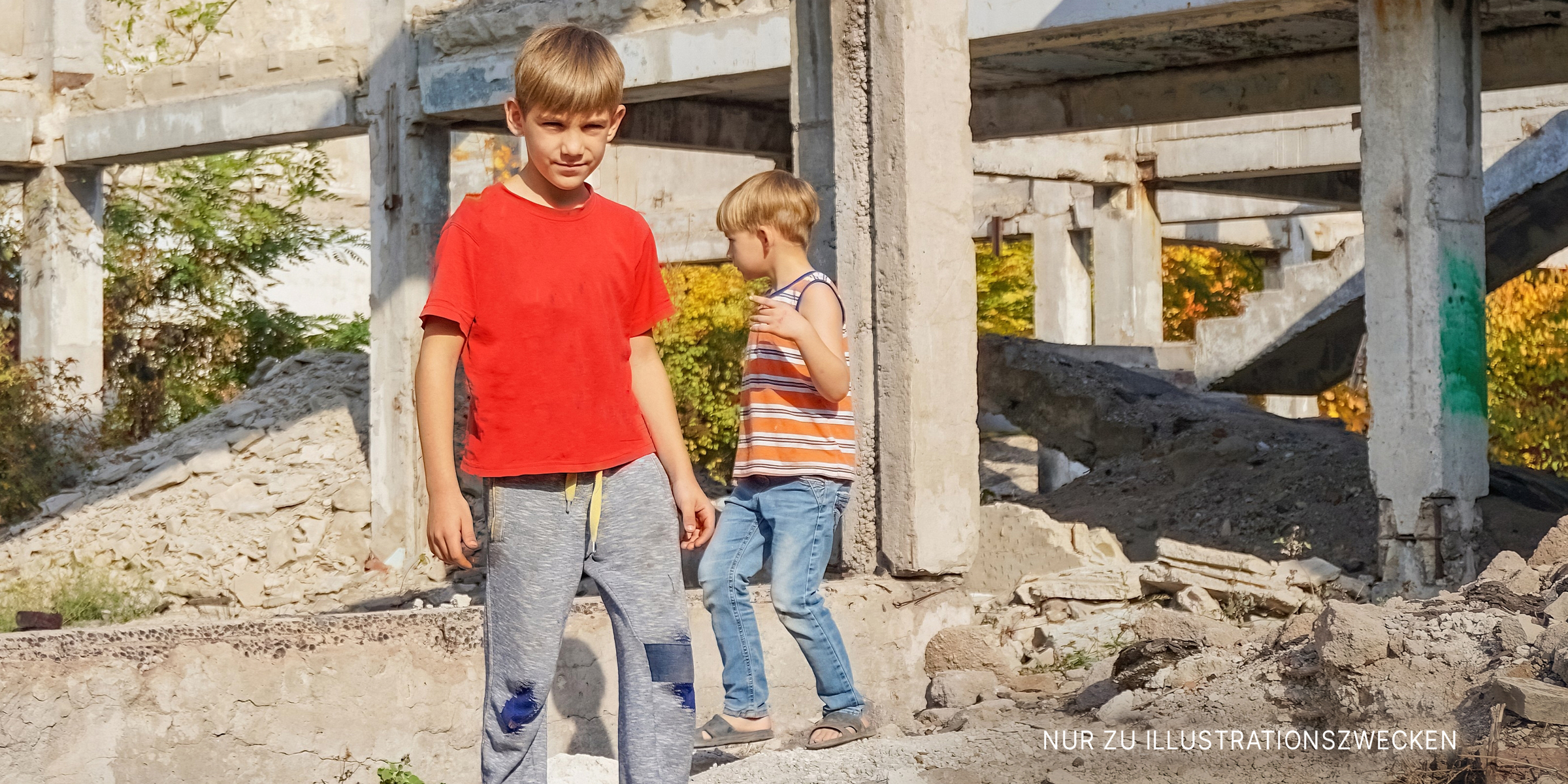 Zwei Jungen stehen neben alten Betonpfeilern | Quelle: Shutterstock