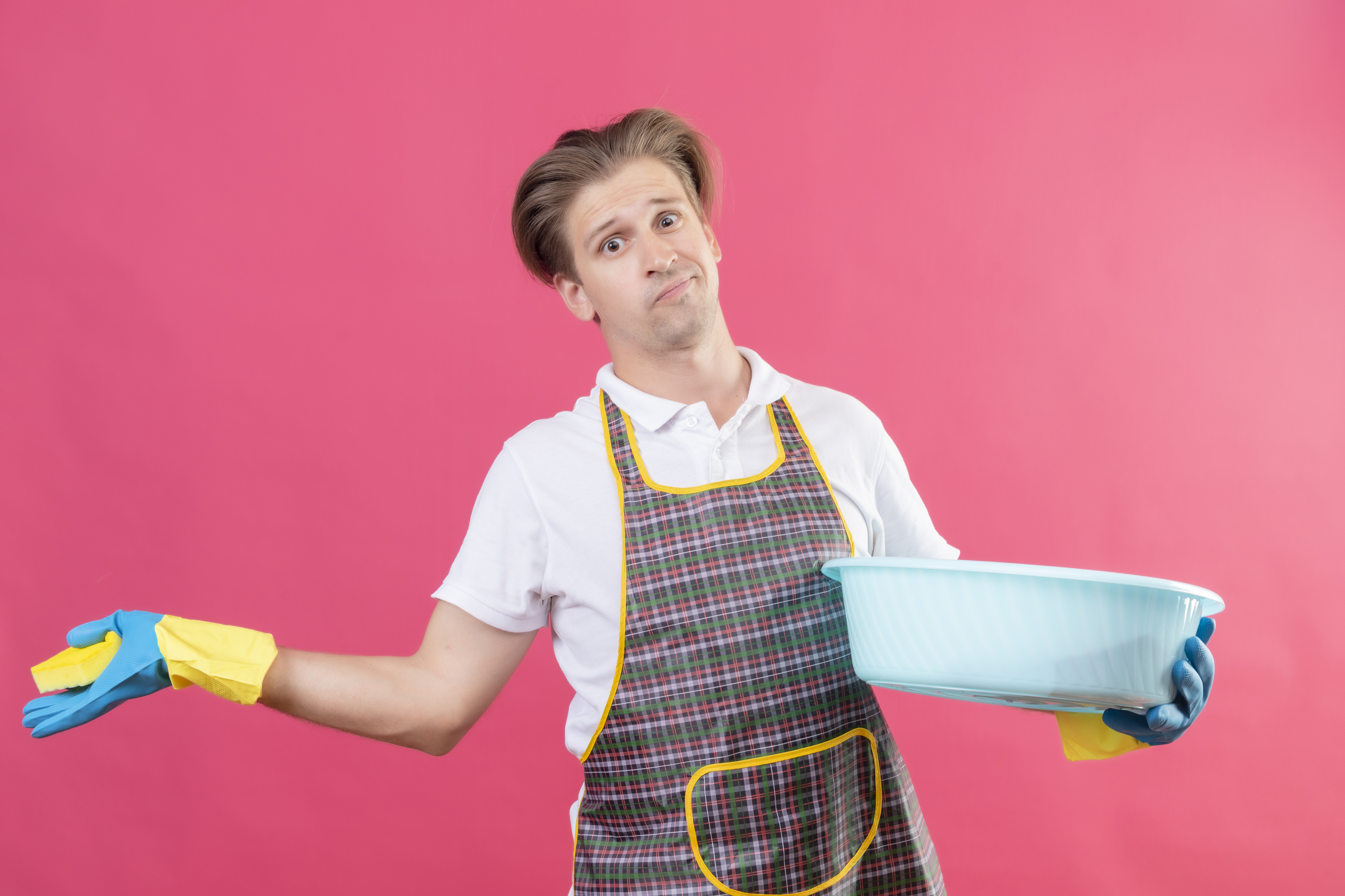 Man wearing an apron and holding a basin, looking confused | Source: stockking on Freepik