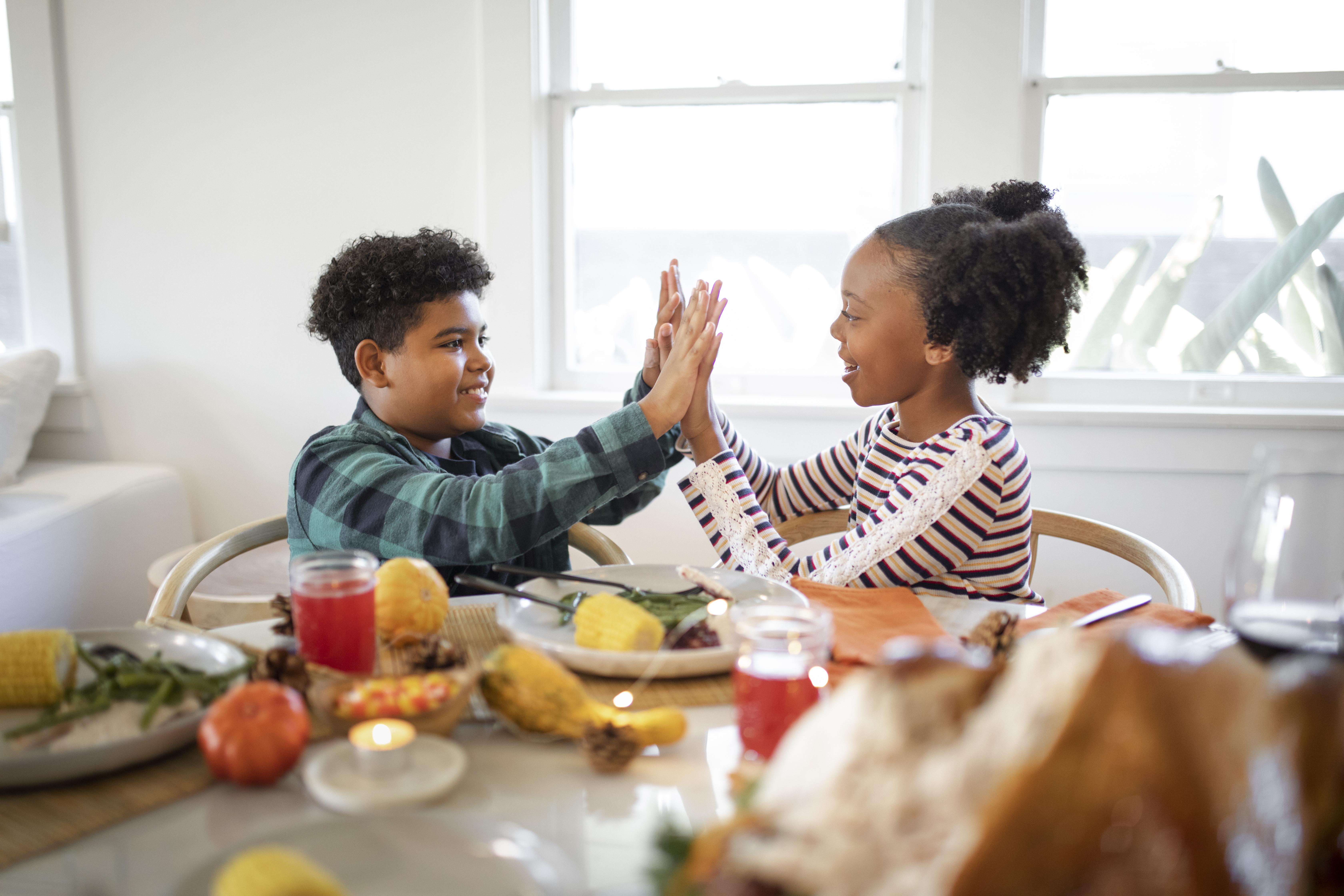Two kids playing at a dinner table | Source: Freepik