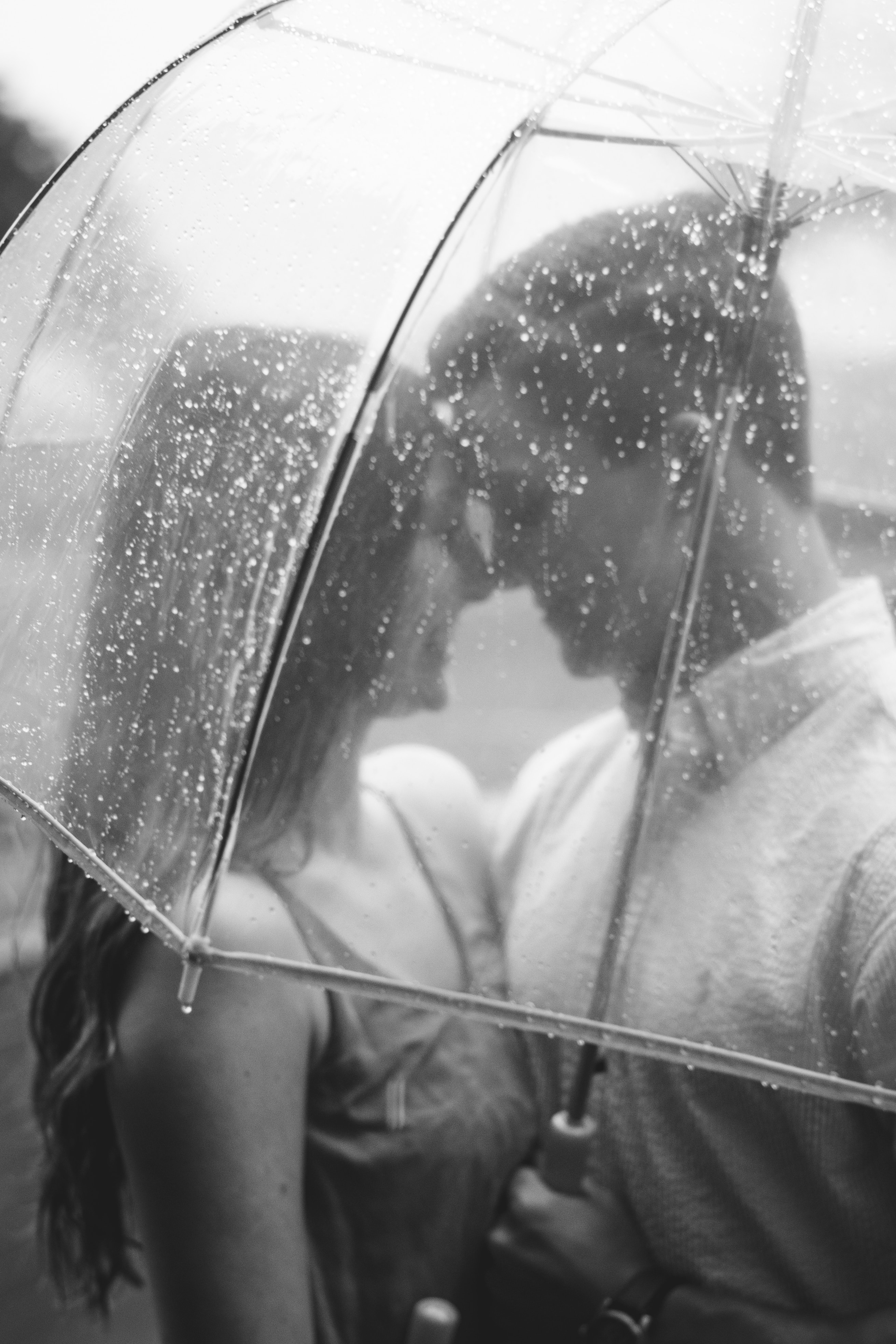 Woman immaculately smiling at her partner under a transparent umbrella | Source: Unsplash