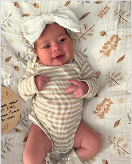 A photo of Kirk Cameron's first grandchild, Maya Jeanne Noble Bower wearing a brown and white stripped onesie posted on July 29, 2024 | Source: Instagram/ahnacameronbower