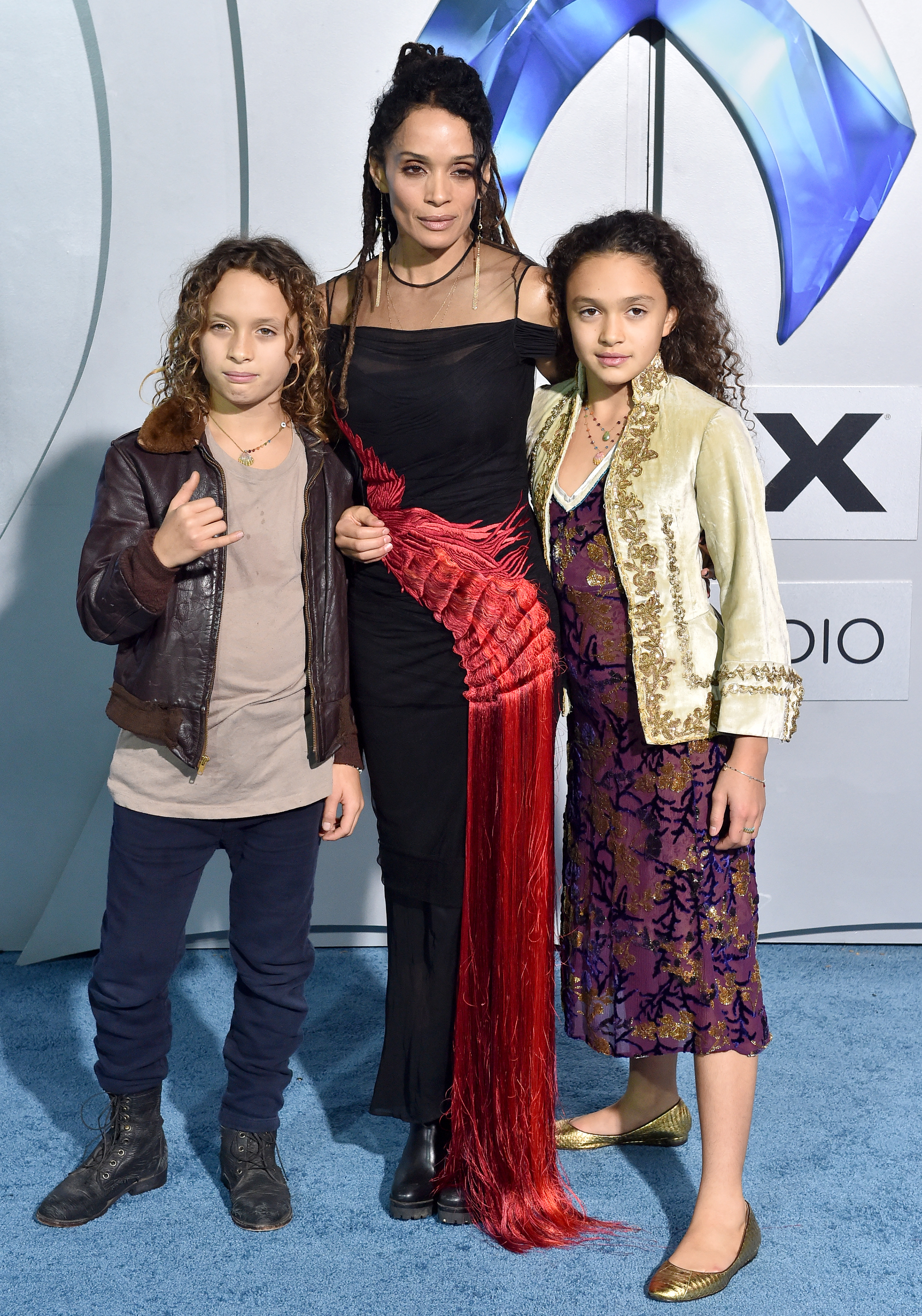 Lisa Bonet struck a poised stance on the "Aquaman" red carpet with her children, Nakoa-Wolf and Lola Iolani Momoa. With Nakoa-Wolf's cool, casual look and Lola's regal style, the family delivered a striking, composed portrait.