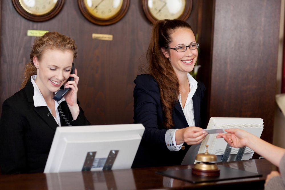 A photo of two receptionists at a reception desk | Photo: Shutterstock