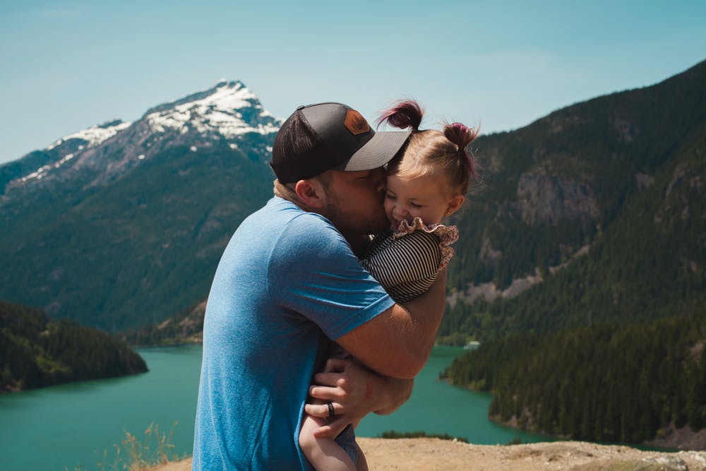 Un padre y una niña divirtiéndose cerca de las montañas. | Foto: Pexels