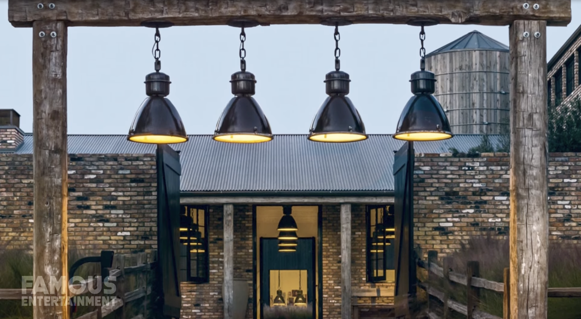 Exterior view of Diane Keaton’s Sullivan Canyon home with hanging industrial lights and brick façade, dated February 3, 2022 | Source: YouTube/@FamousEntertainment500k
