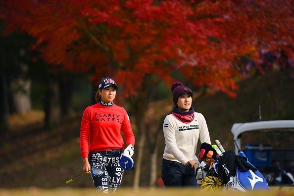 A golfer and her caddie pictured having a walk during the final round of the Japanese LPGA Final Qualifying Tournament | Photo: Getty Images