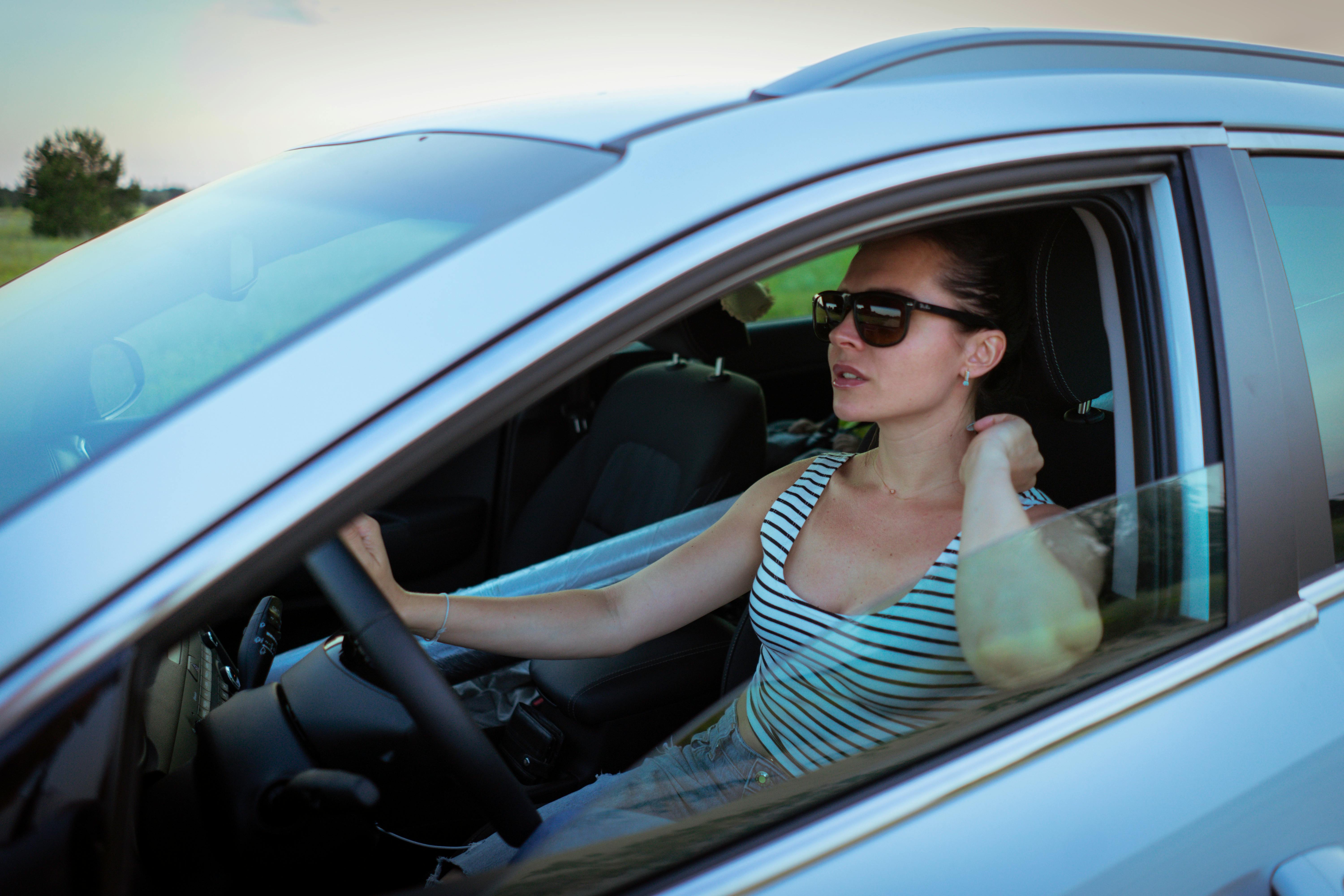 A woman driving while wearing sunglasses | Source: Pexels