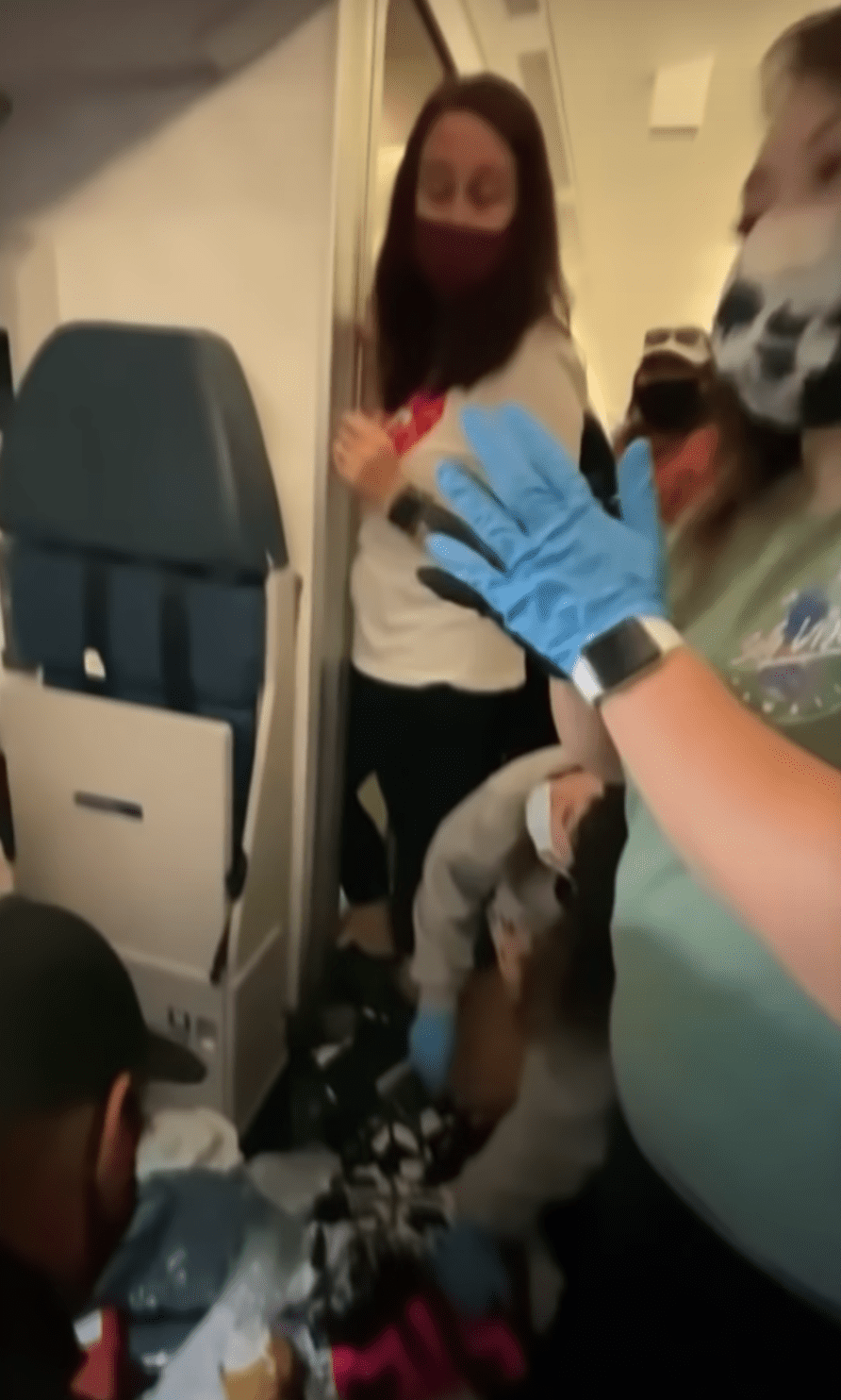 Krankenschwestern und Ärzte helfen einer Frau, die mitten im Flug entbunden hat. | Quelle: Youtube.com/TheEllenShow