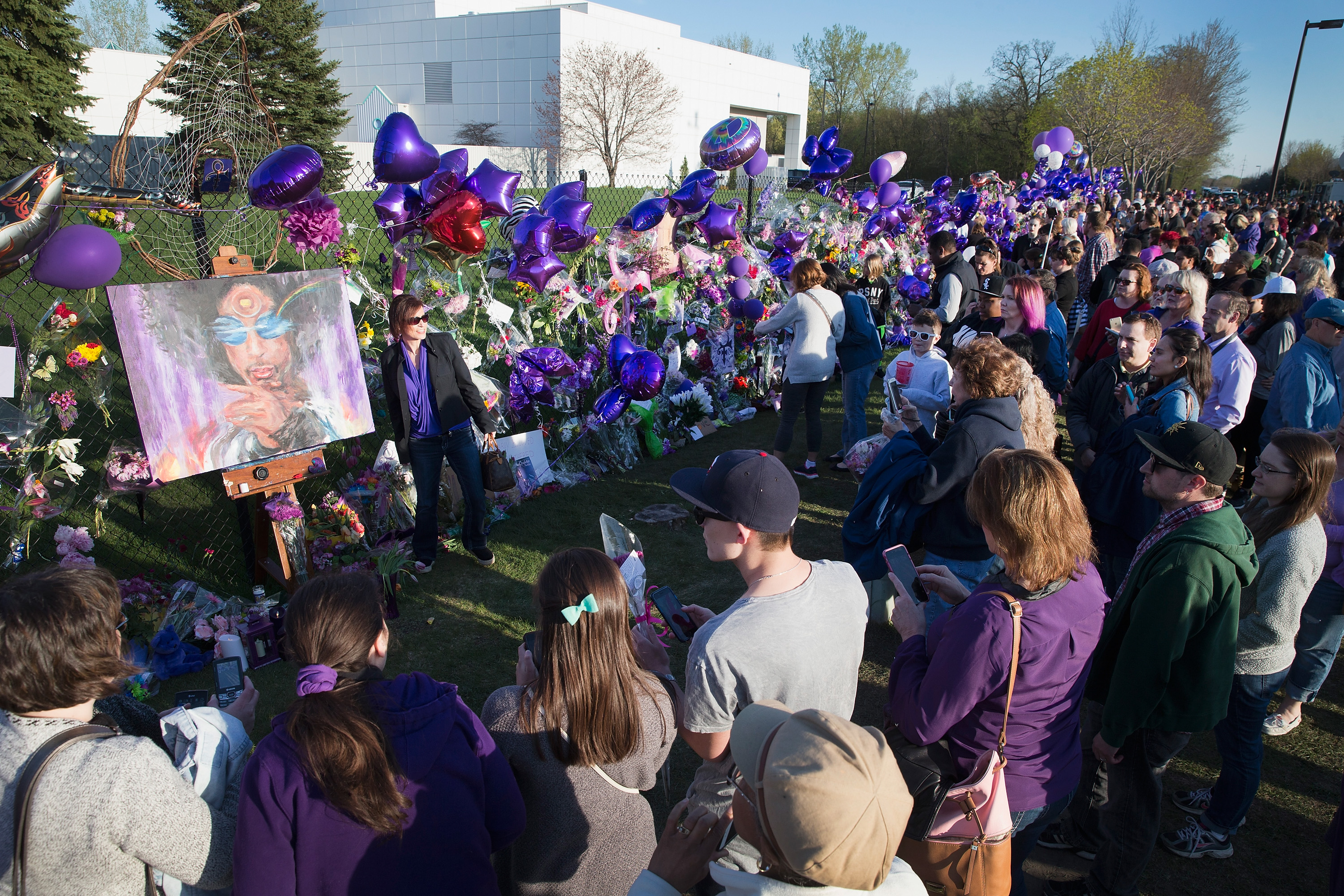 Mourning fans visit a memorial outside Paisley Park, the home and studio of the late Prince, on April 22, 2016 in Chanhassen, Minnesota | Source: Getty Images