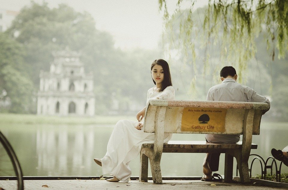 Paar sitzt mit Rücken zueinander auf einer Bank | Quelle: Pixabay