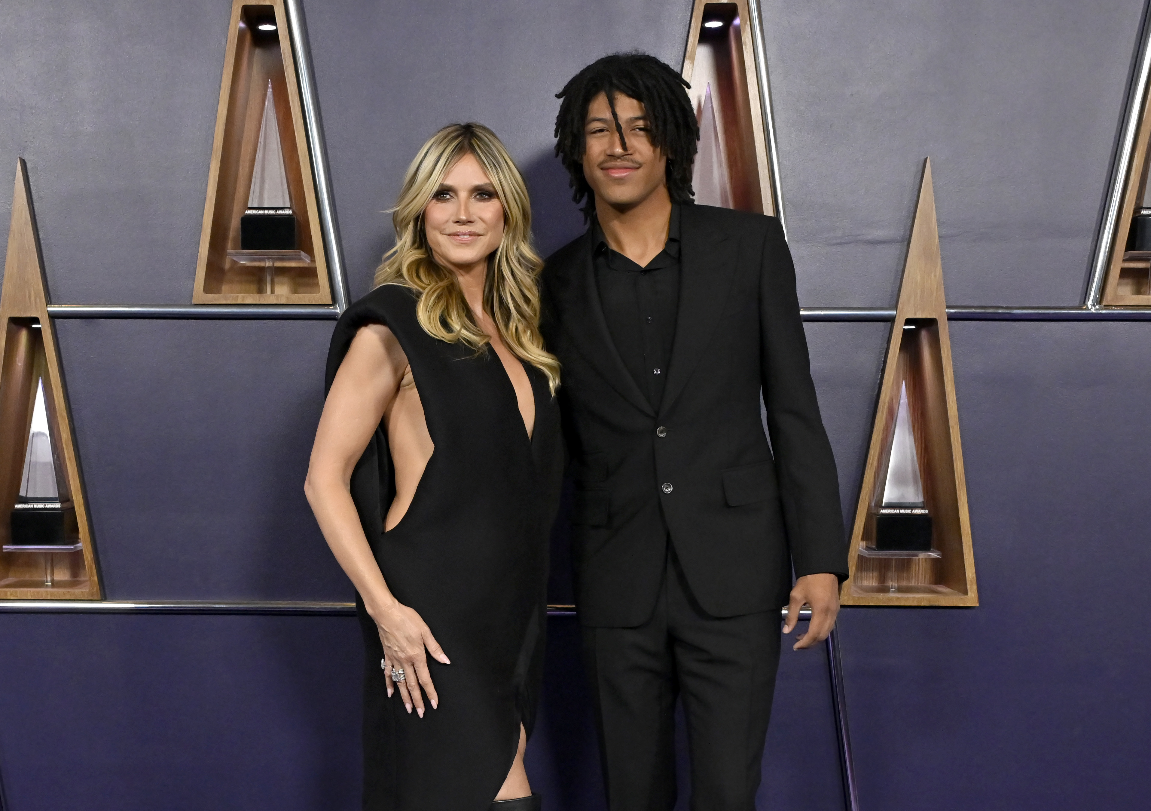 With subtle smiles and effortless poise, Heidi Klum and Henry Samuel make a sleek mother-son statement on the AMAs red carpet.