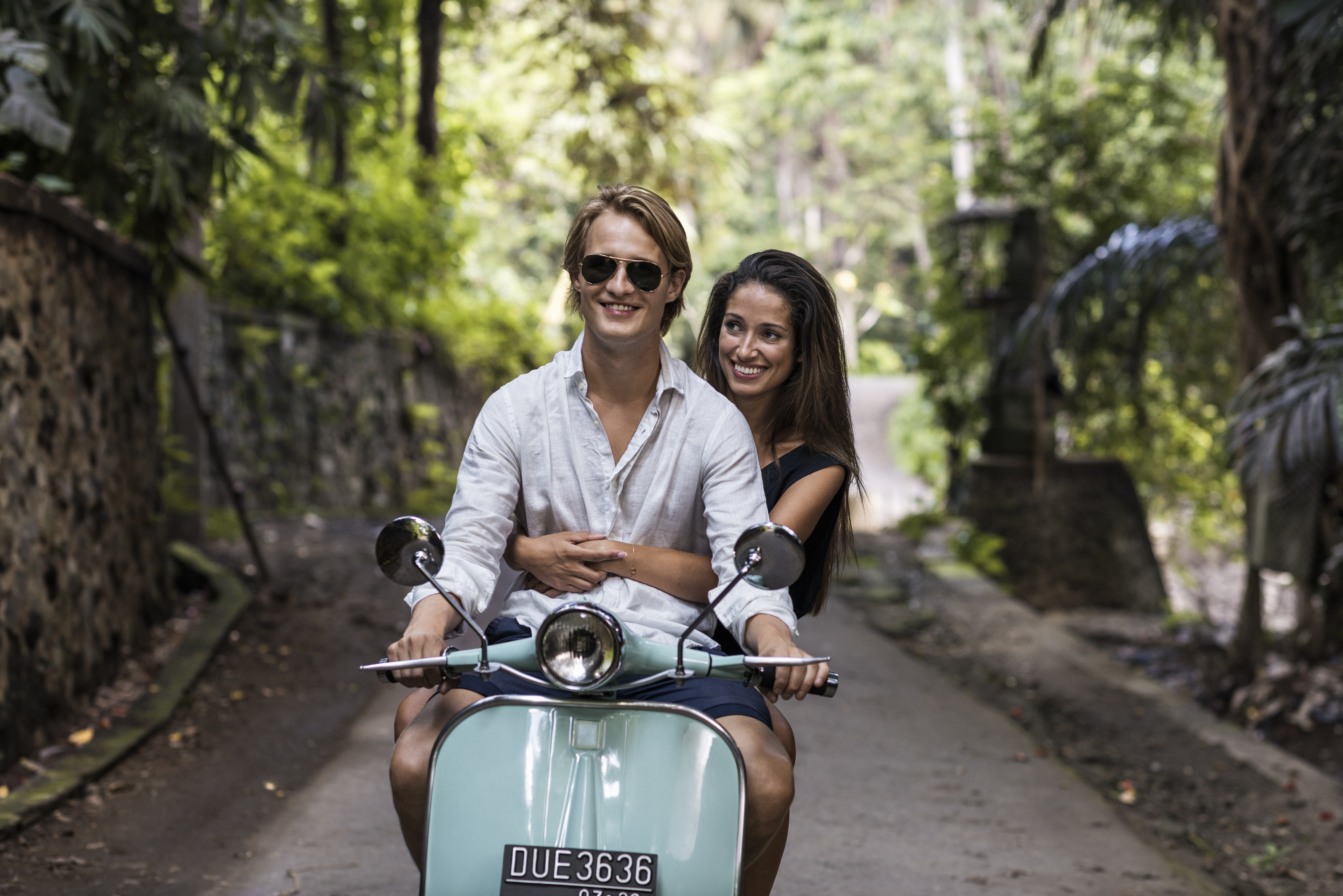 Young couple riding classic scooter during vacation in Bali | Source: Getty Images