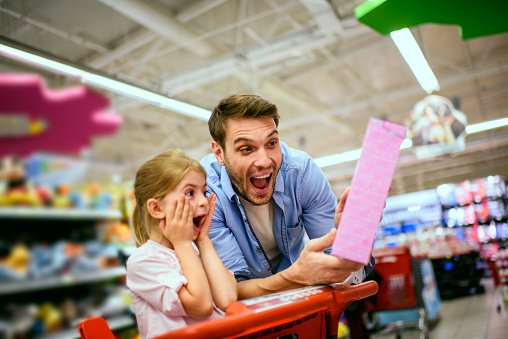 Photo of father buying a gift to his daughter in toy store. | Photo: Getty Images