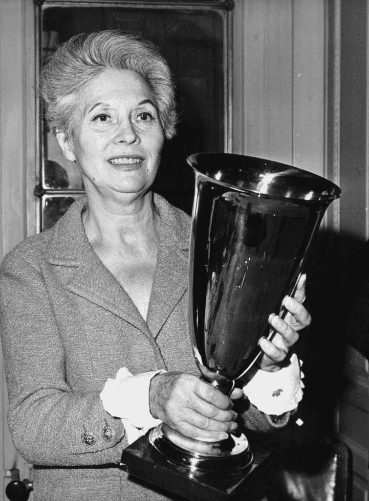 27 février 1965: l'actrice française Arletty avec la coupe dorée Lafaurie-Trebor, qui lui a été présentée par l'Association des Optimistes, après avoir récemment été menacée de cécité. | Photo : Getty Images