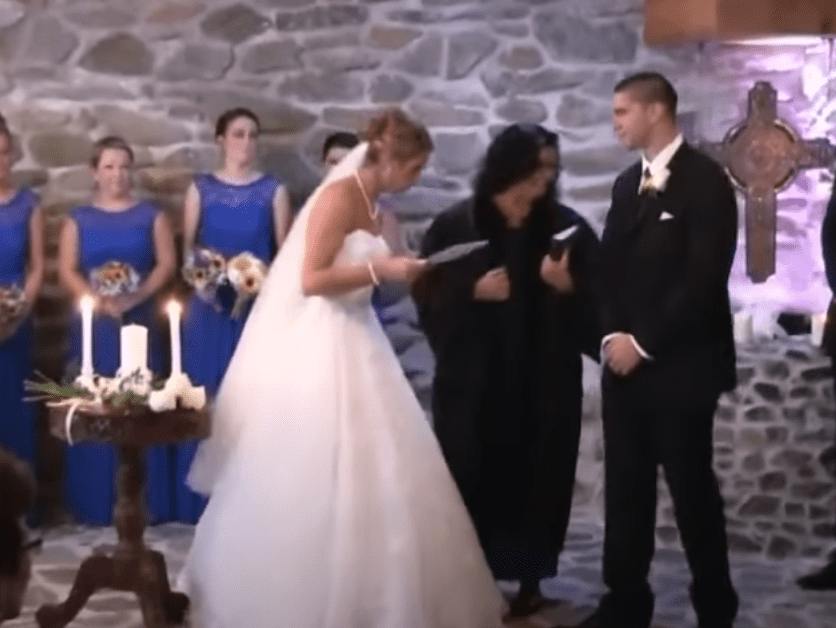 A bride reads her vows to her groom and then unexpectedly includes her new step-son and his mother | Photo: Youtube/Inside Edition