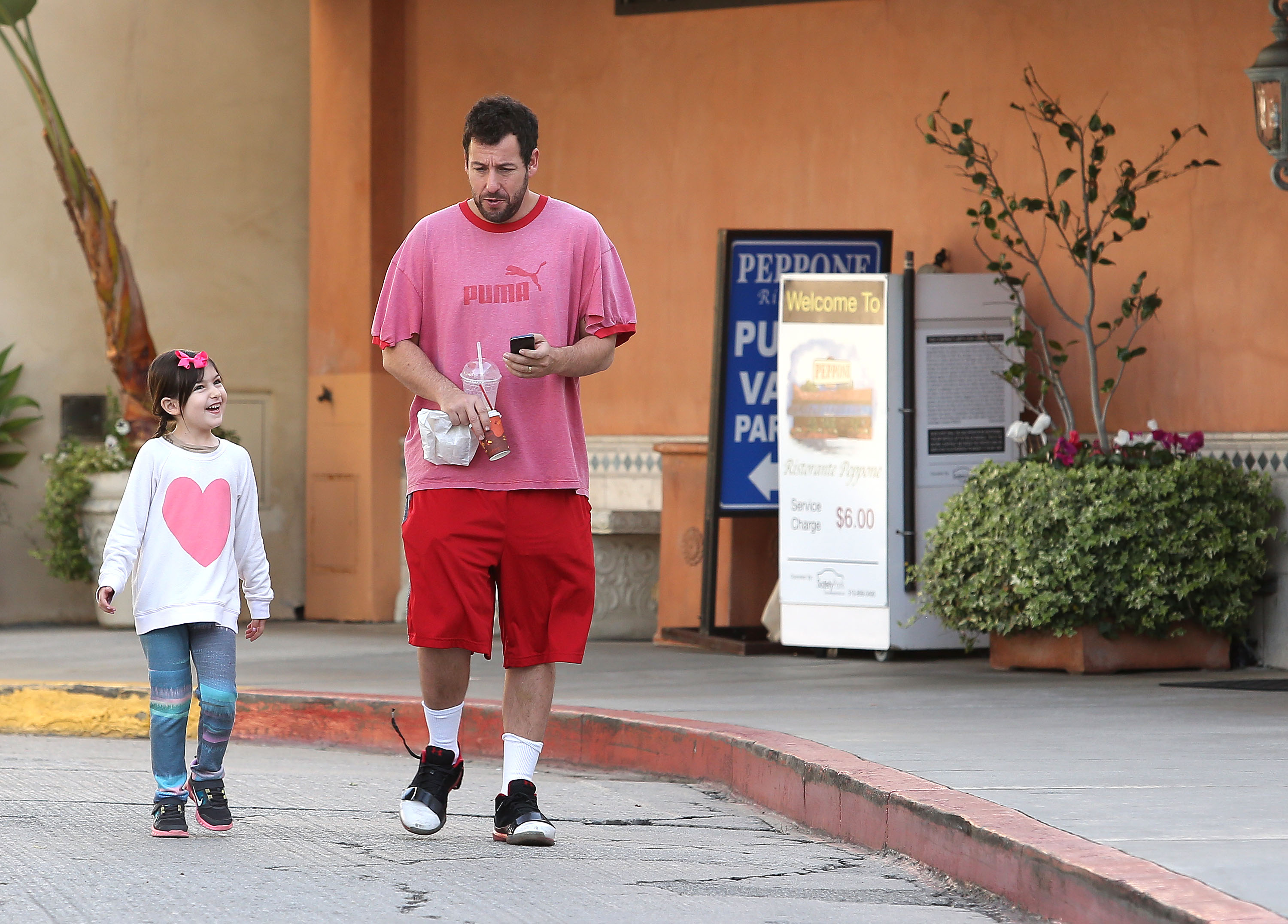 Adam is seen with Sunny Sandler in Los Angeles on December 17, 2013. | Source: Getty Images