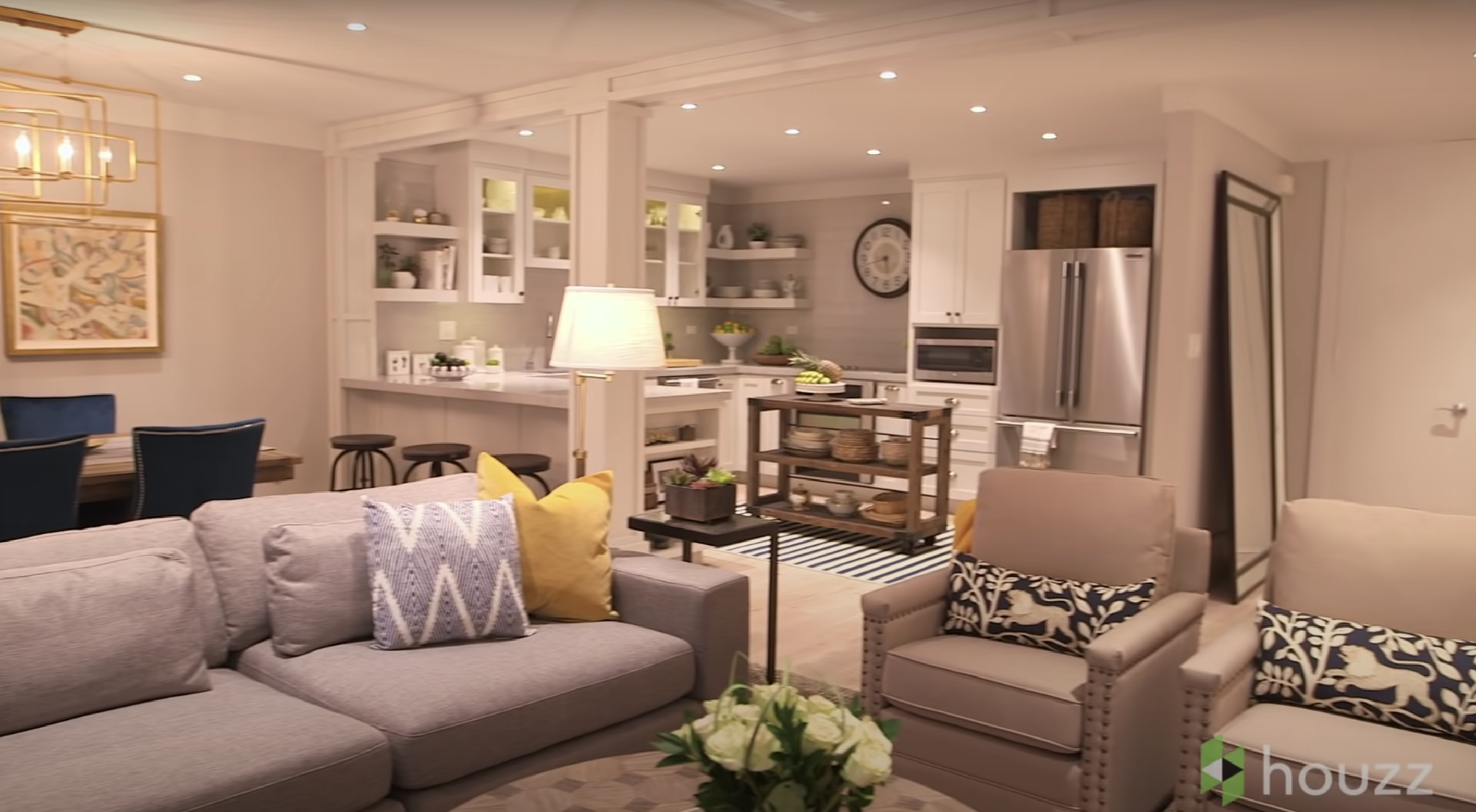 A photo showing the revamped living space and kitchen area of Mila Kunis' family condo | Source: Youtube.com/HouzzTV