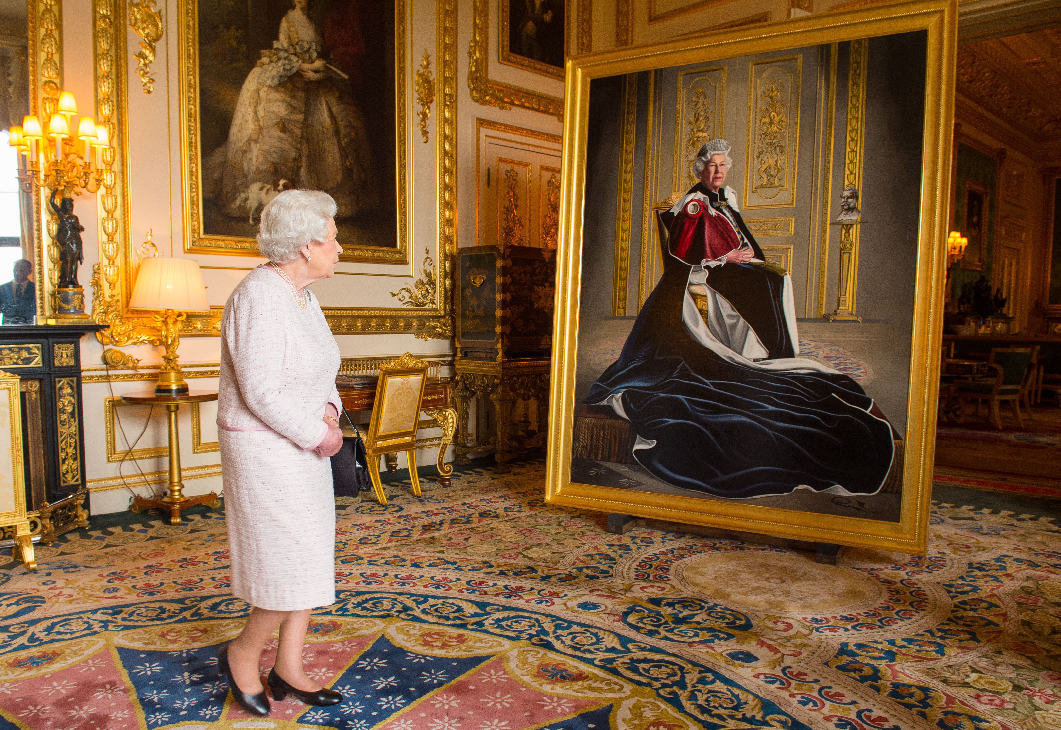 Queen Elizabeth II views a portrait of herself by British artist Henry Ward, marking six decades of patronage to the British Red Cross, which has been unveiled at Windsor Castle on October 14, 2016 in Windsor, England. | Source: Getty Images