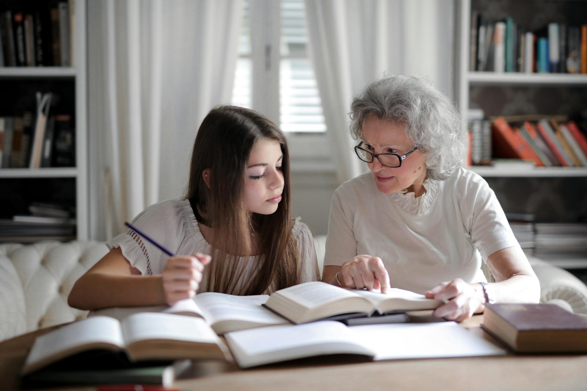 An older woman helping a young girl with her studies | Source: Pexels