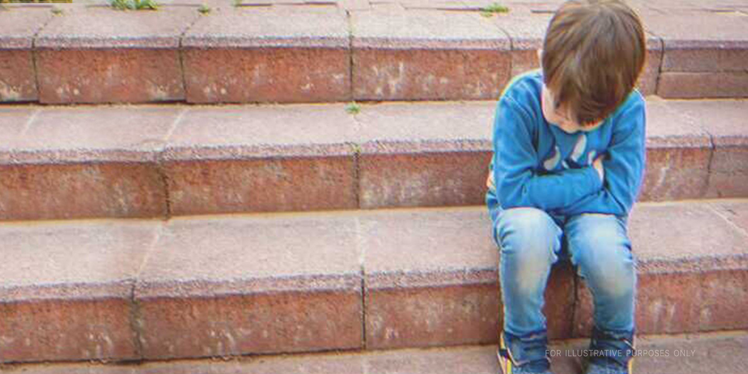 An upset boy sitting on steps | Source: Shutterstock