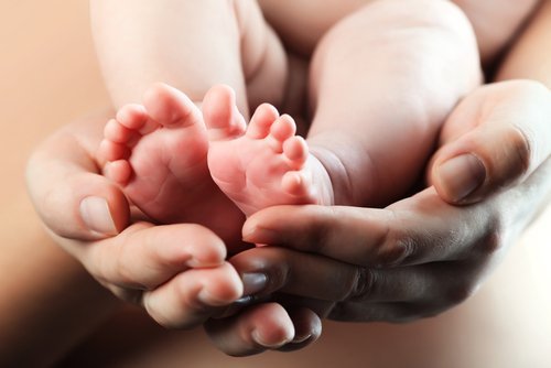 Baby's foot in mother hands | Photo: Shutterstock