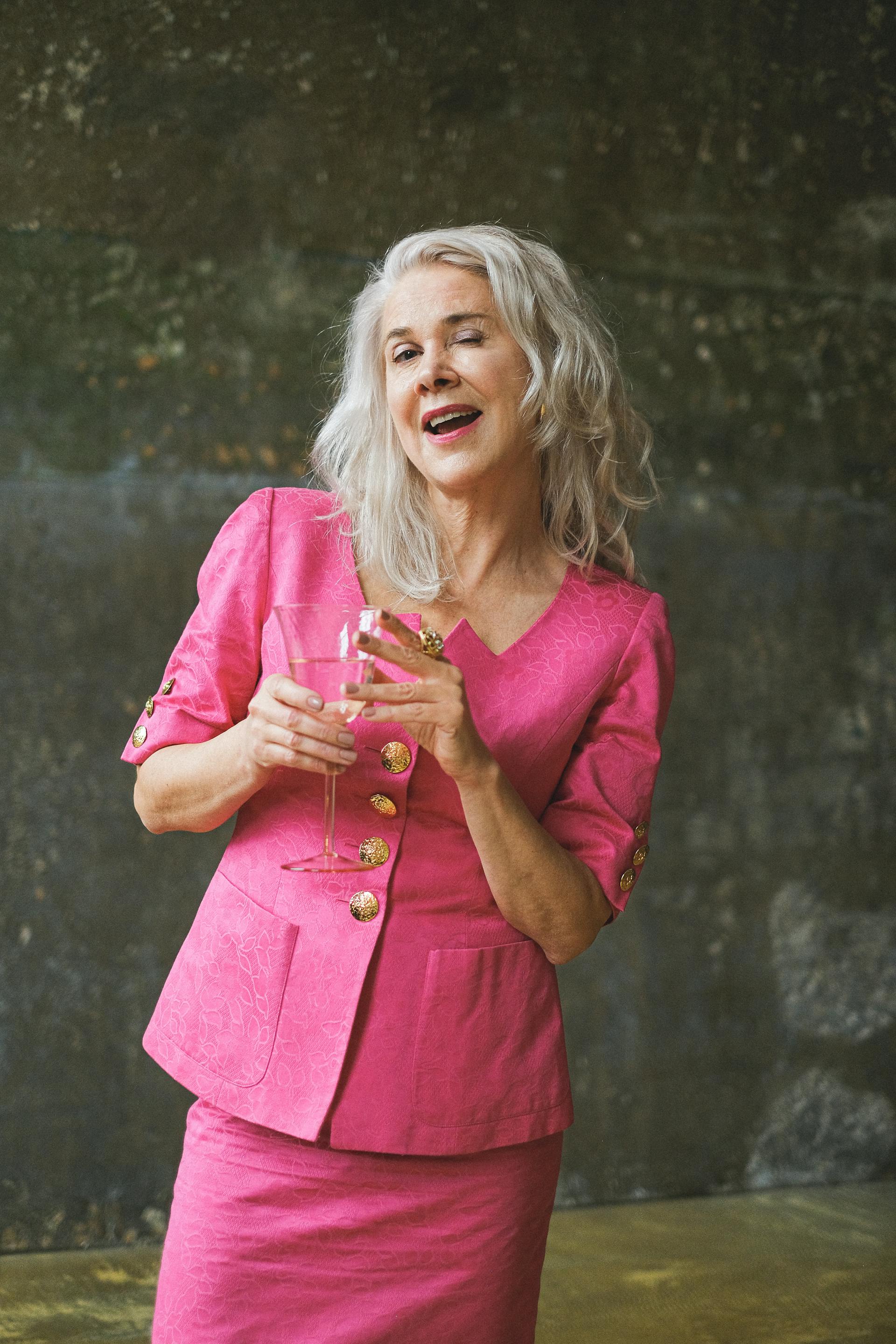 A smiling senior woman holding a glass of wine | Source: Pexels