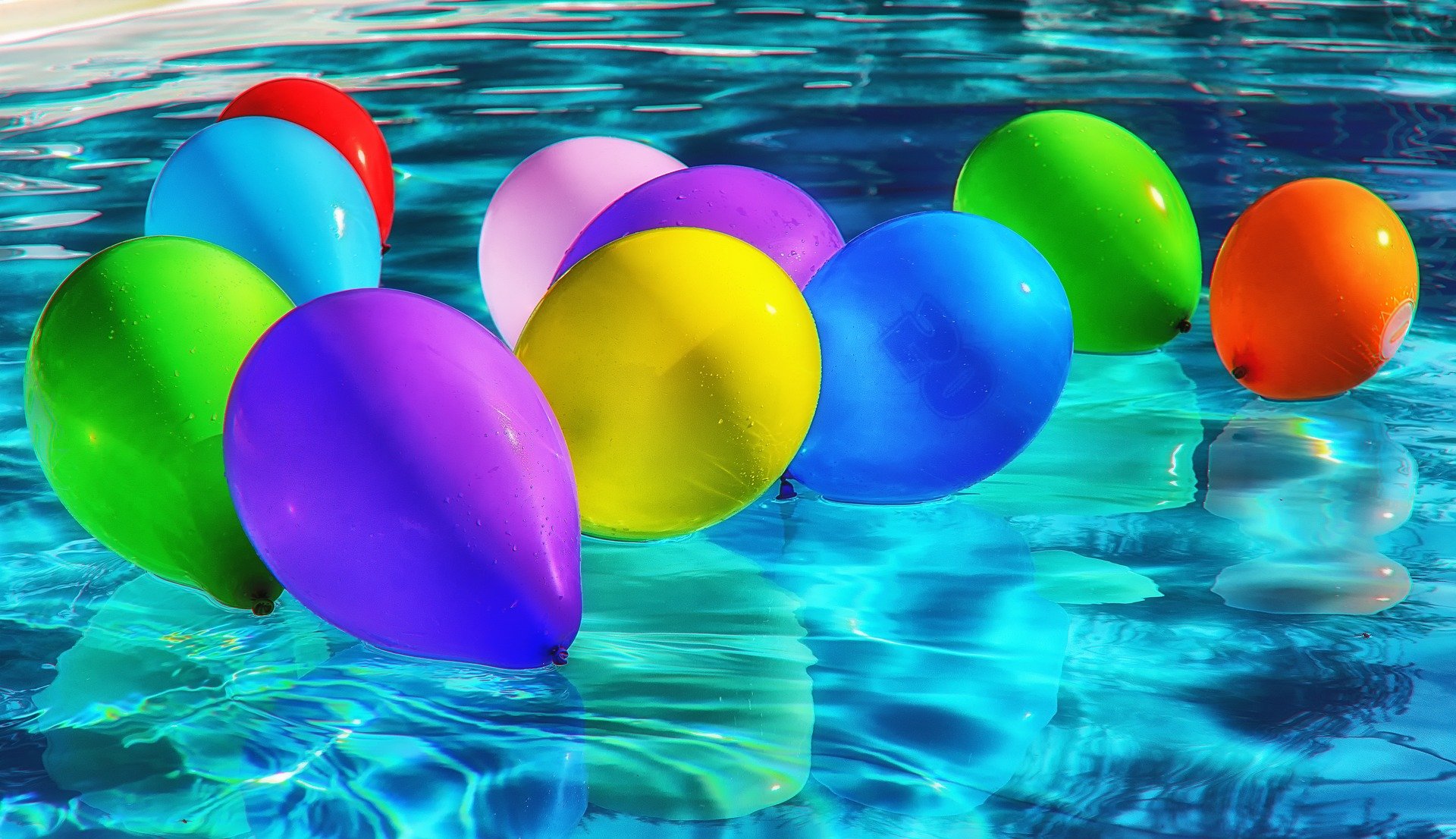 Balloons festively floating in a swimming pool. | Source: Pixabay.