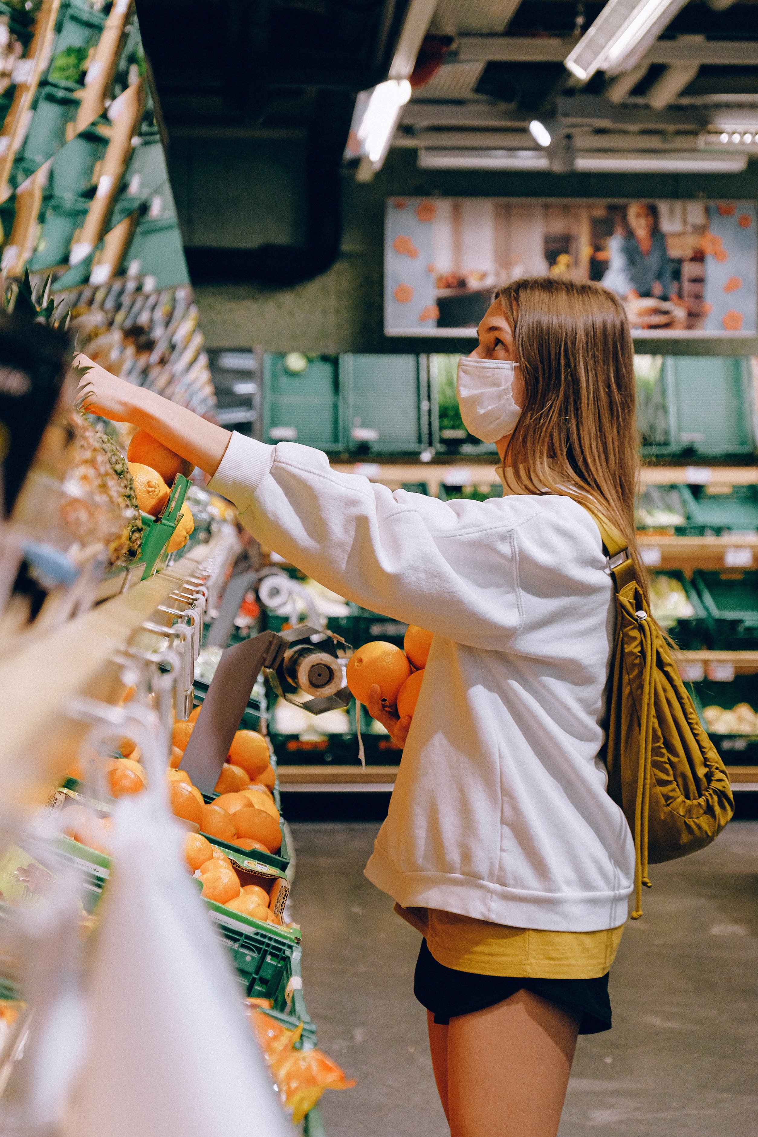 Joven con mascarilla en el rostro haciendo las compras en el supermercado. | Foto: Pexels